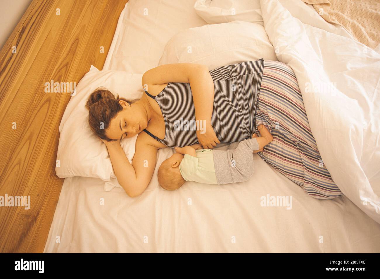 Mother and newborn baby sleep in the bed Stock Photo