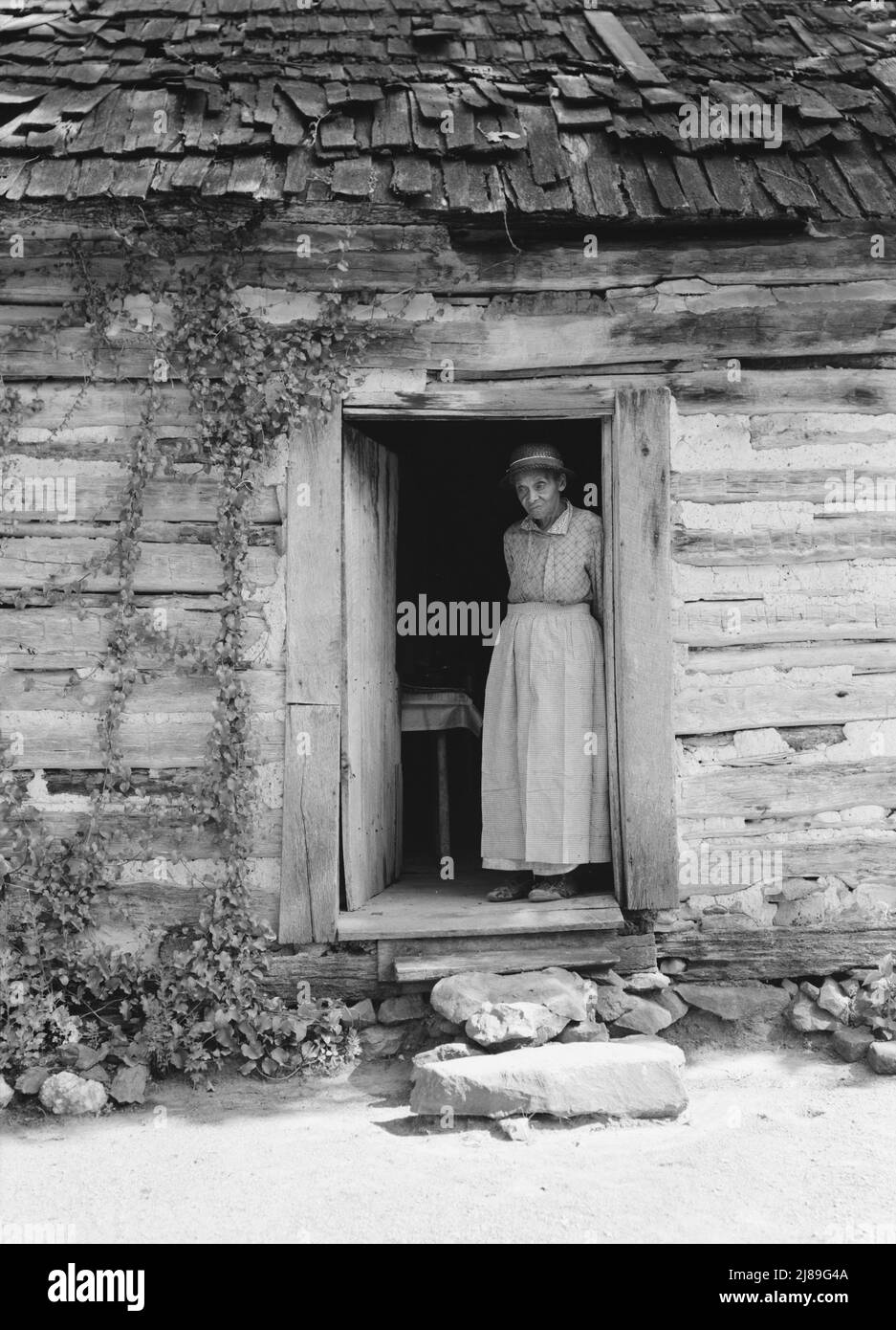 Caroline Atwater standing in the kitchen doorway of double one and a half story log house. North Carolina. Stock Photo