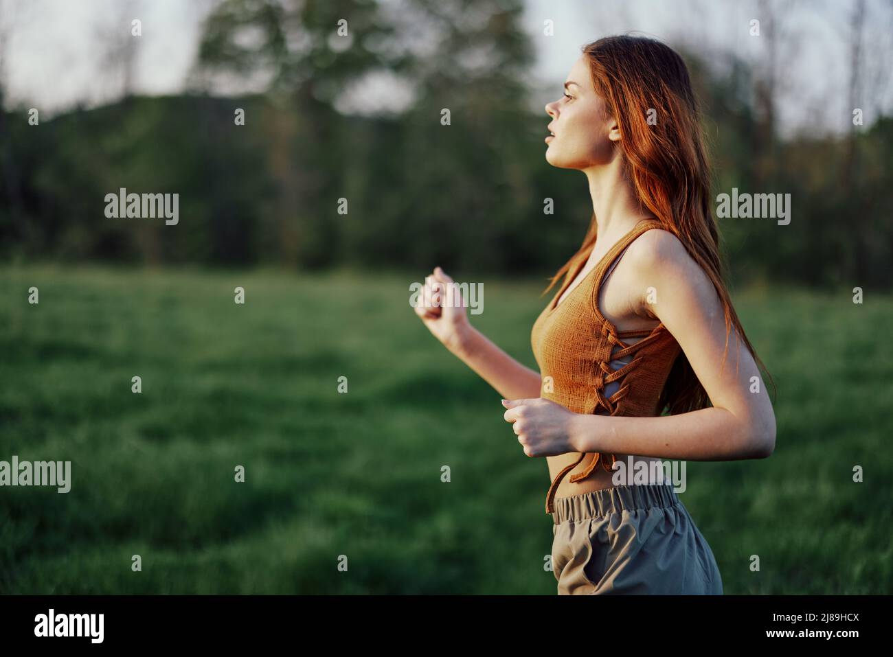 A woman is jogging with a focused face, tired after an outdoor activity