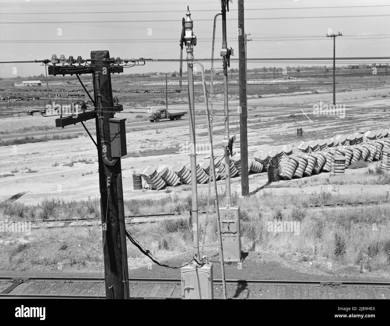 Between Tulare and Fresno, California. From the overpass approaching Fresno. [Bales of cotton outside the Producers Cotton Oil Co., makers of cottonseed cake and meal for cattle and sheep]. Stock Photo