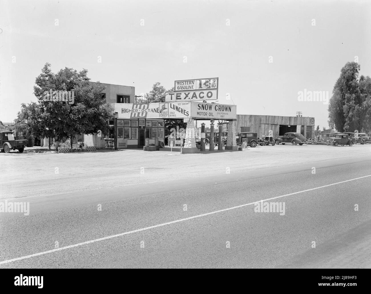 Near Kingsburg. Small independent gas stations litter the highway. California. [Signs: 'Higher Octane; Fire-Chief Gasoline; Ice Cream, Lunches, Cold Drinks; Western Gasoline; Texaco; Snow Grown Motor Oil Stock Photo