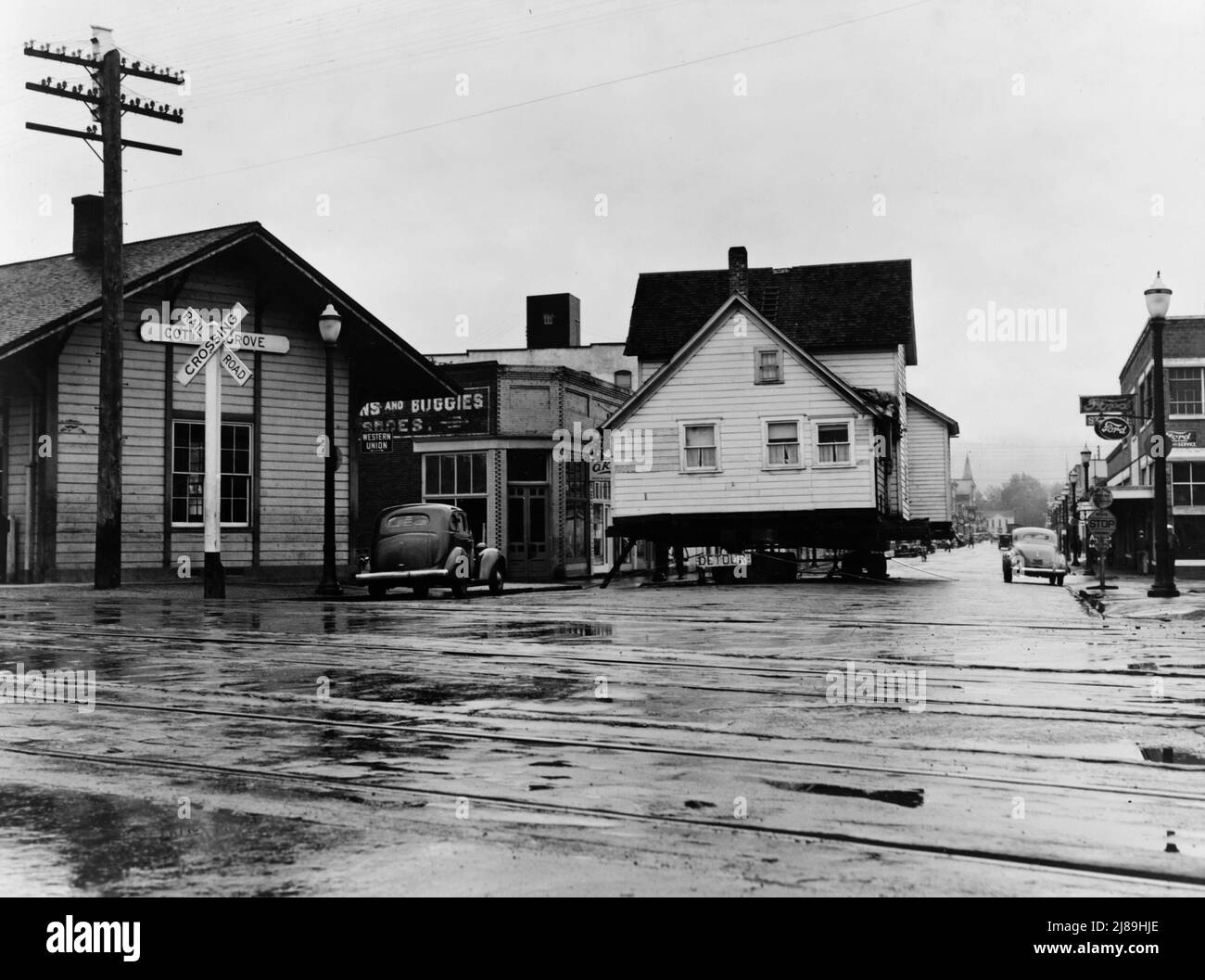 House being moved through the main street of town (population 2473). Deposited over Sunday on intersection of U.S. 99. Quiet, rainy afternoon. Cottage Grove, Lane County, Oregon. Stock Photo
