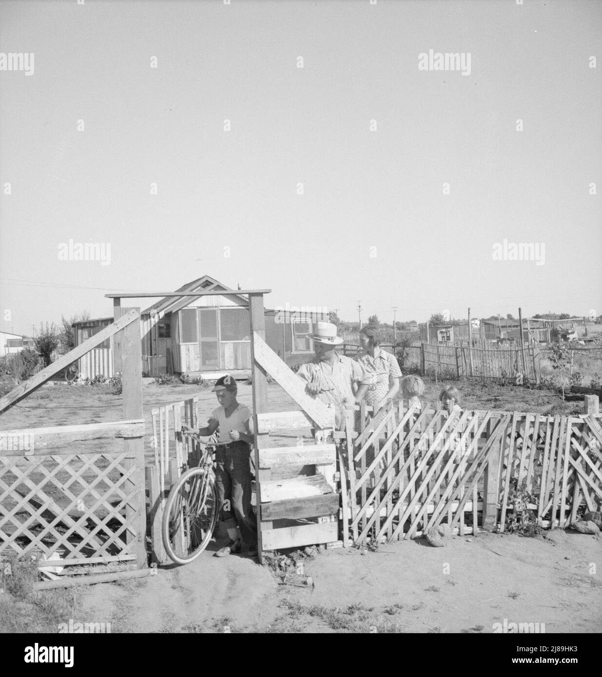 Highway City, California, near Fresno. Family from Oklahoma; have been in California for six years, have been migratory workers now on Works Progress Administration (WPA) from which they may be cut off at the opening of the 1939 harvest. Their house represents one of many similar structures, which they are attempting to construct by their own efforts on poor land, for which they are paying a few dollars a month out of the WPA budget. Their light bill is two dollars a month. Water bill one dollar a month, kerosene for cooking five dollars per month, approximately. They own a 1929 Ford. &quot;Th Stock Photo