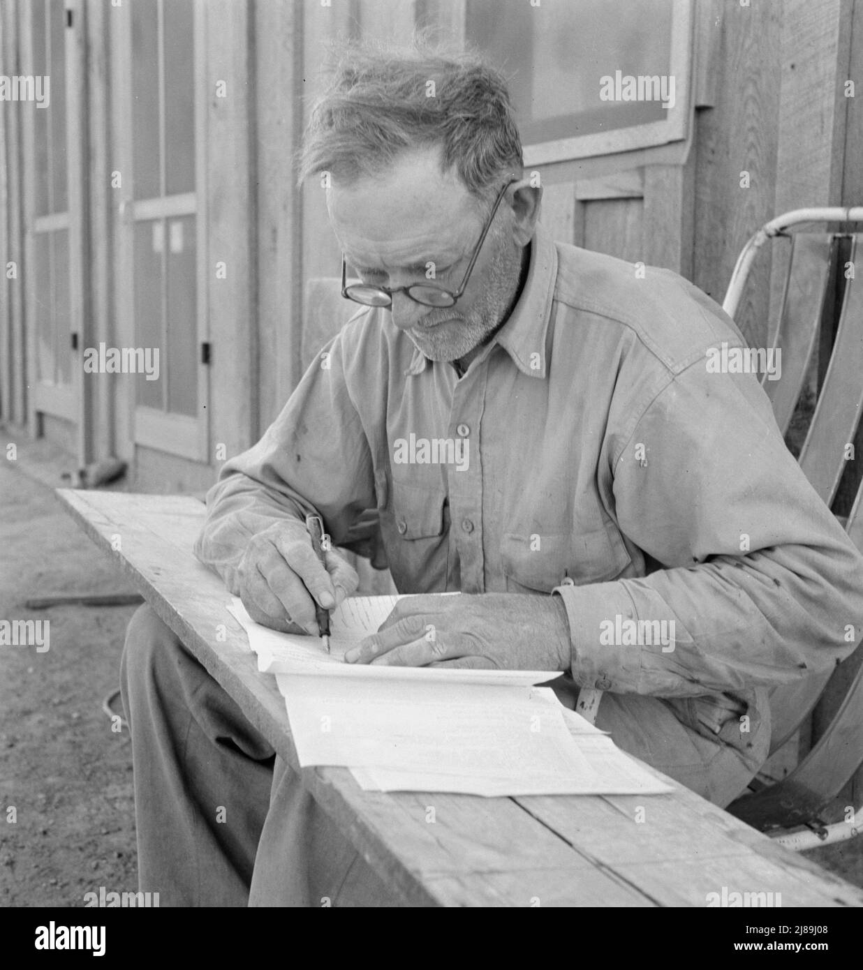 Oklahoma farmer, now living in Cow Hollow, is a FSA (Farm Security Administration) borrower. Seen here signing his chattel mortgage. Malheur County, Oregon. [Mr. Sam Cates]. Stock Photo