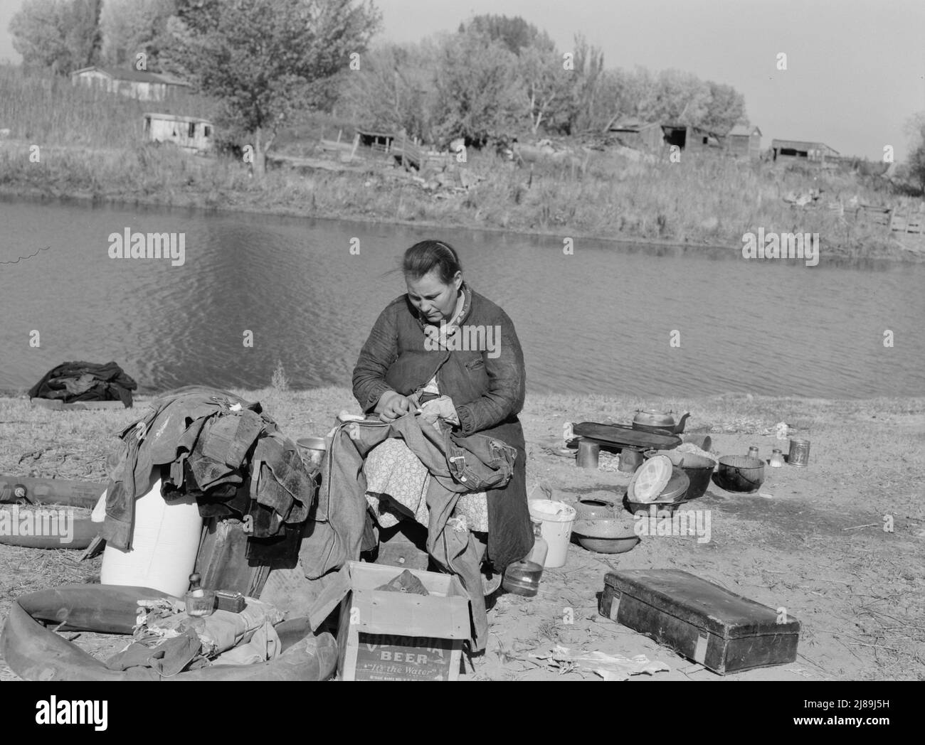 Mother of migrant family sewing. Near Vale, Malheur County, Oregon. Stock Photo