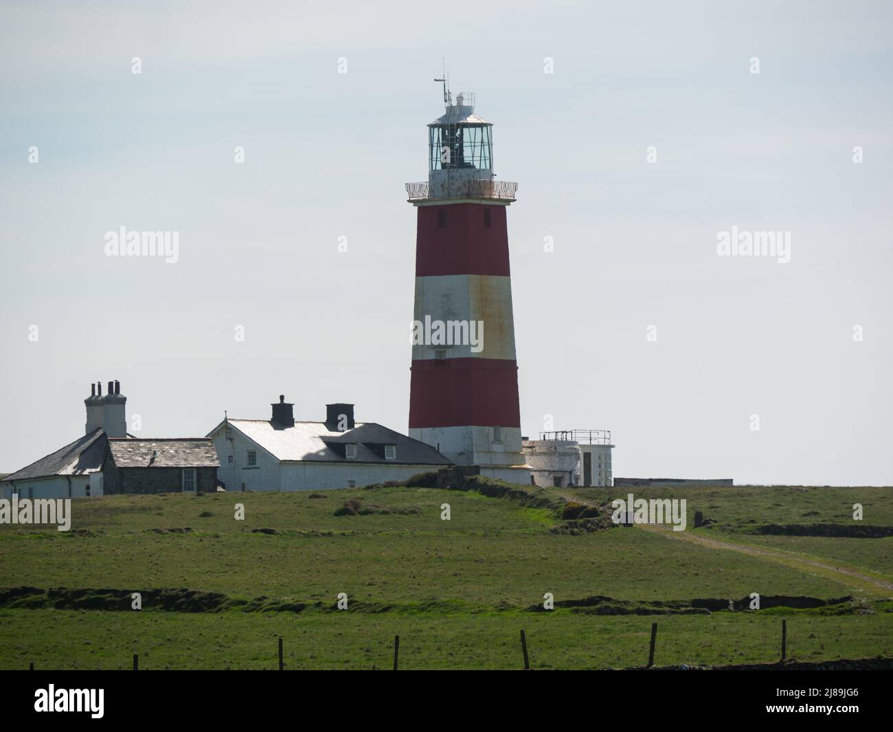 Bardsey Lighthouse stands on the southerly tip of Bardsey Island off Llŷn Peninsula in Gwynedd Wales UK and guides vessels passing through St George's Stock Photo