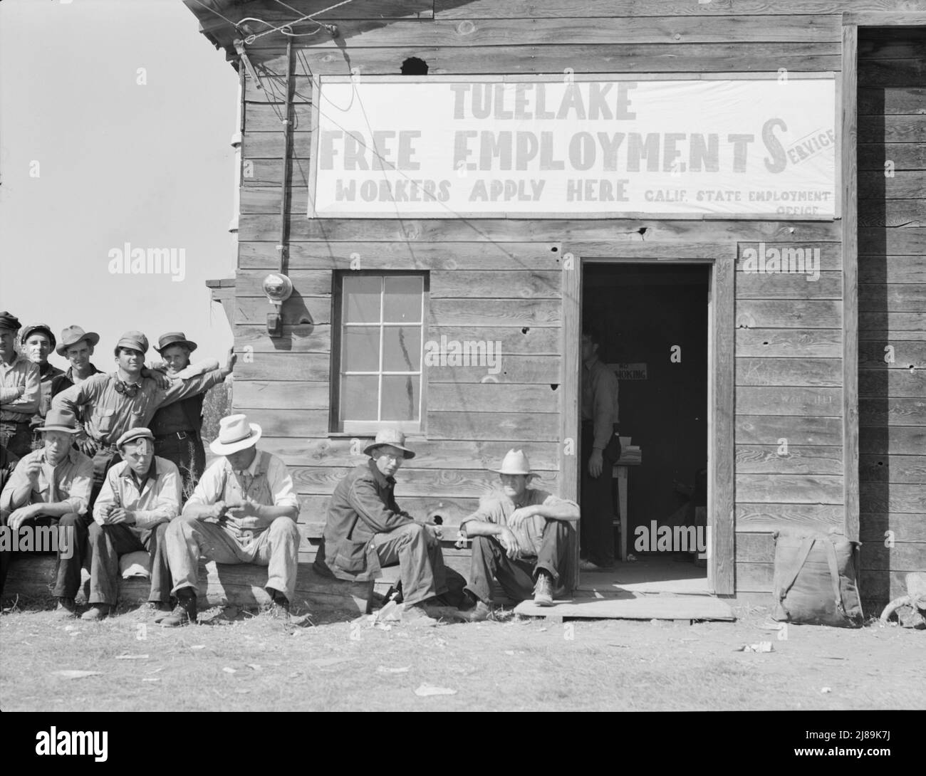 California State Employment Service office. Tulelake, Siskiyou County, California. This office is 500 yards from potato pickers camp. This office made 2,452 individual placements to growers in five weeks (season of 1938). [Sign: 'Tulelake Free Employment Service - Workers Apply Here']. Stock Photo