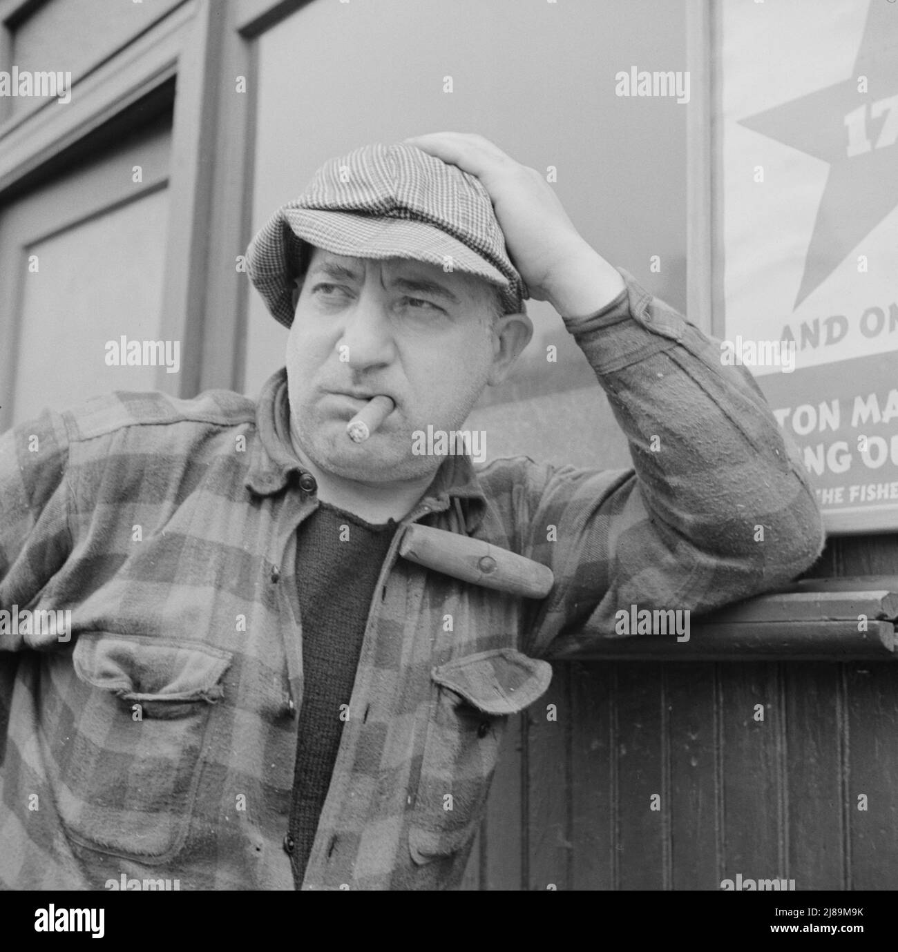 New York, New York. Fulton fish market hooker. [Note wooden-handled hook over his shoulder, used for securing and moving loads]. Stock Photo
