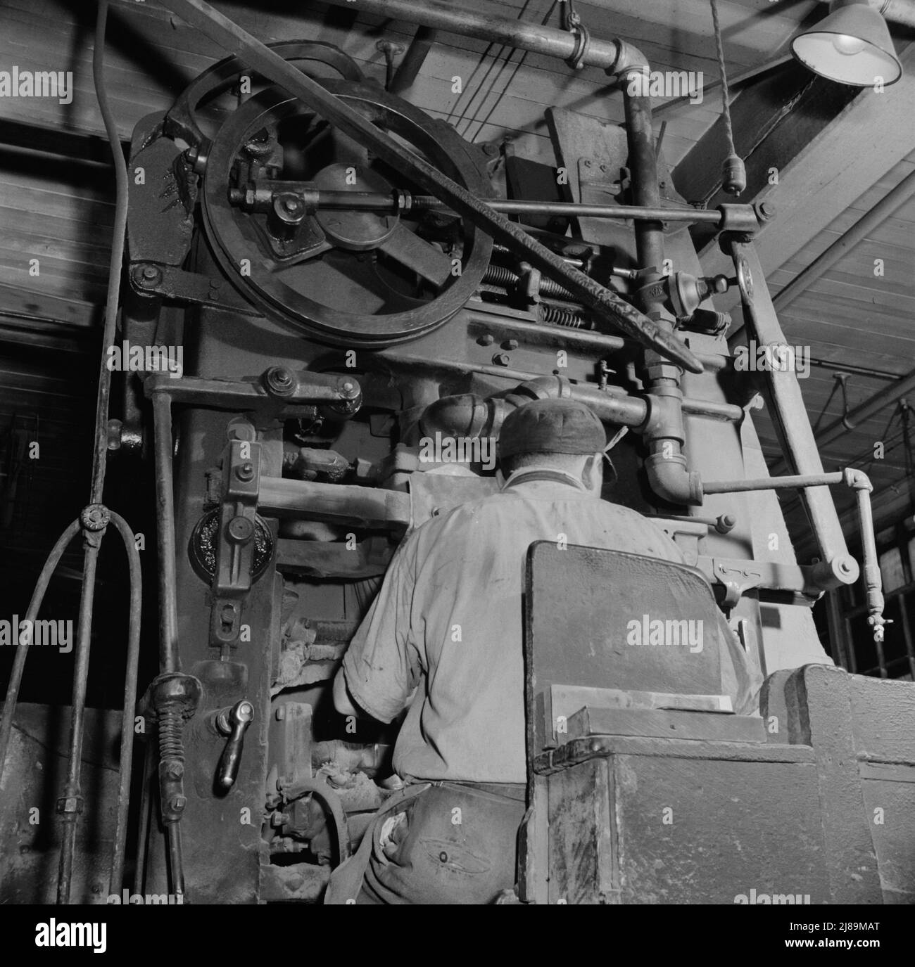 [Untitled photo, possibly related to: New Britain, Connecticut A core blowing machine. Sand is blown into the core box as it travels away from the machine on a conveyor]. Stock Photo