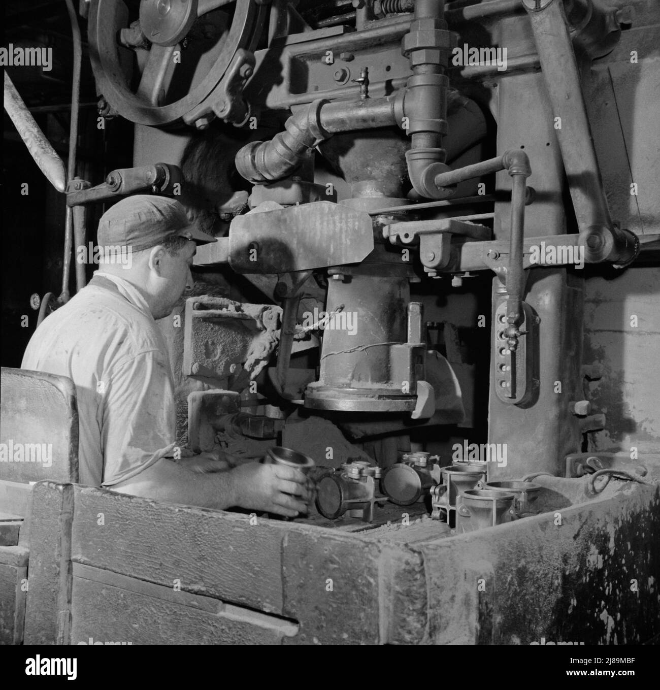 New Britain, Connecticut A core blowing machine. Sand is blown into the core box as it travels away from the machine on a conveyor. Stock Photo