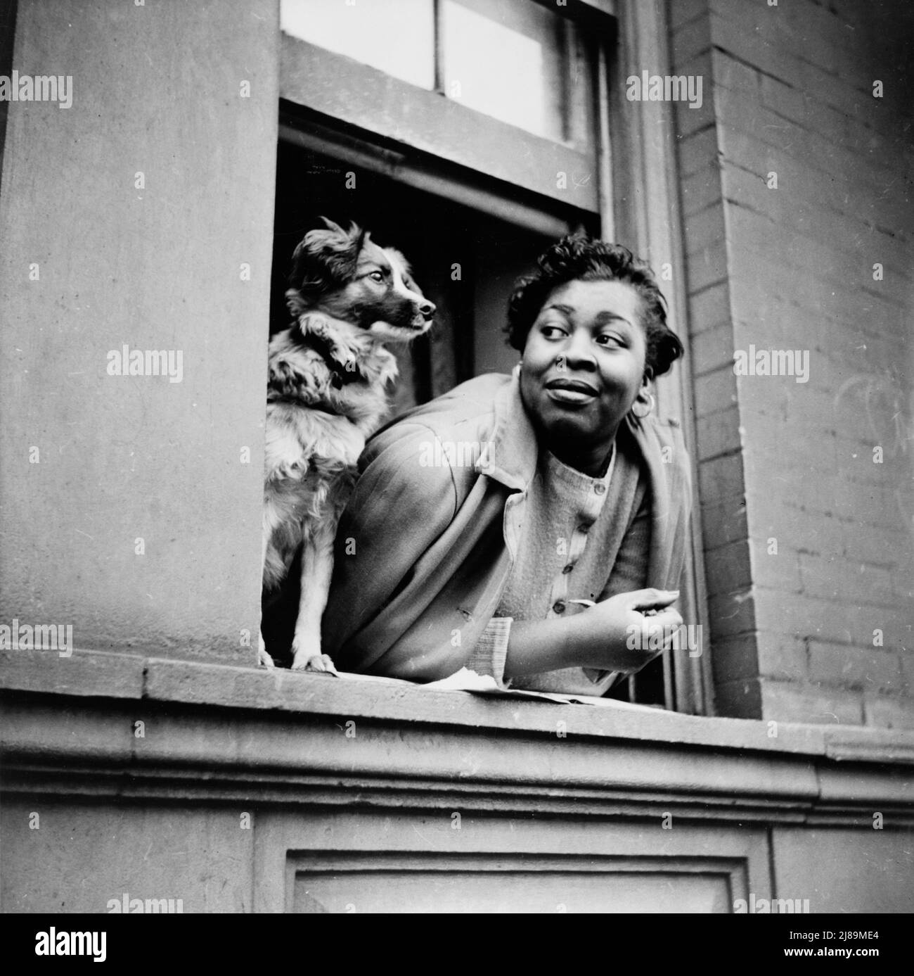 New York, New York. A woman and her dog in the Harlem section. Stock Photo