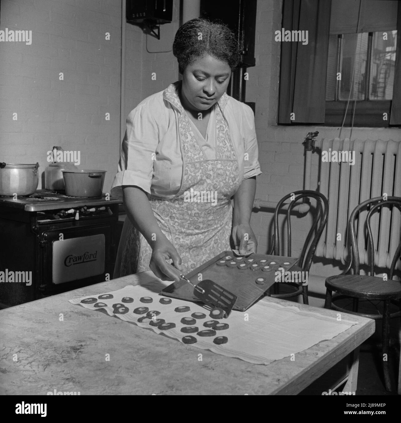 New Britain, Connecticut. A child care center opened September 15, 1942, for thirty children, ages two through five of mothers engaged in war industry. The hours are 6:30 a.m. to 6 p.m. six days per week. The dietician baking cookies. Stock Photo