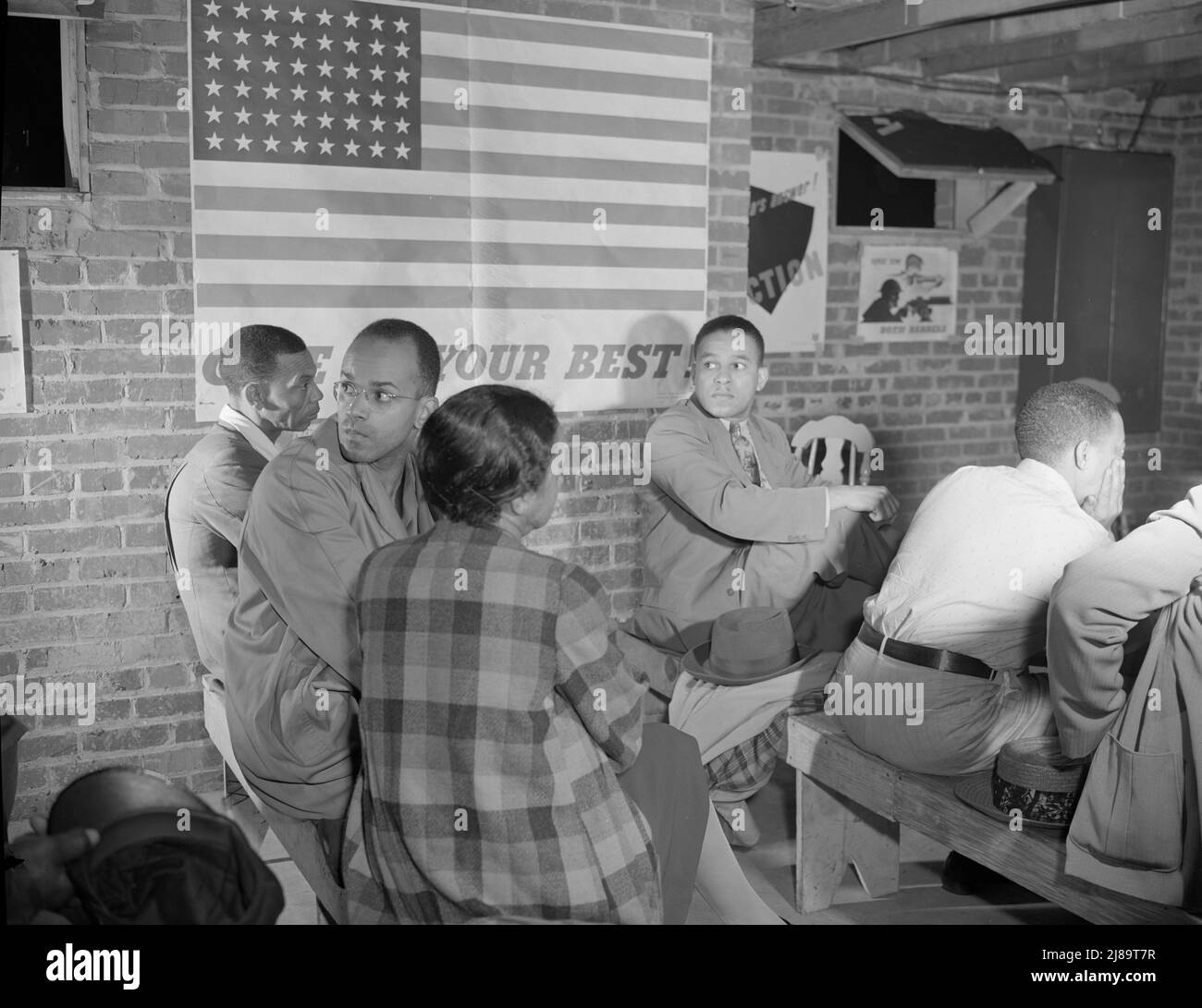 Washington, D.C. Air raid wardens' meeting in zone nine, Southwest area. Air raid wardens listening to a report by one of the wardens at a meeting in their zone headquarters. Stock Photo