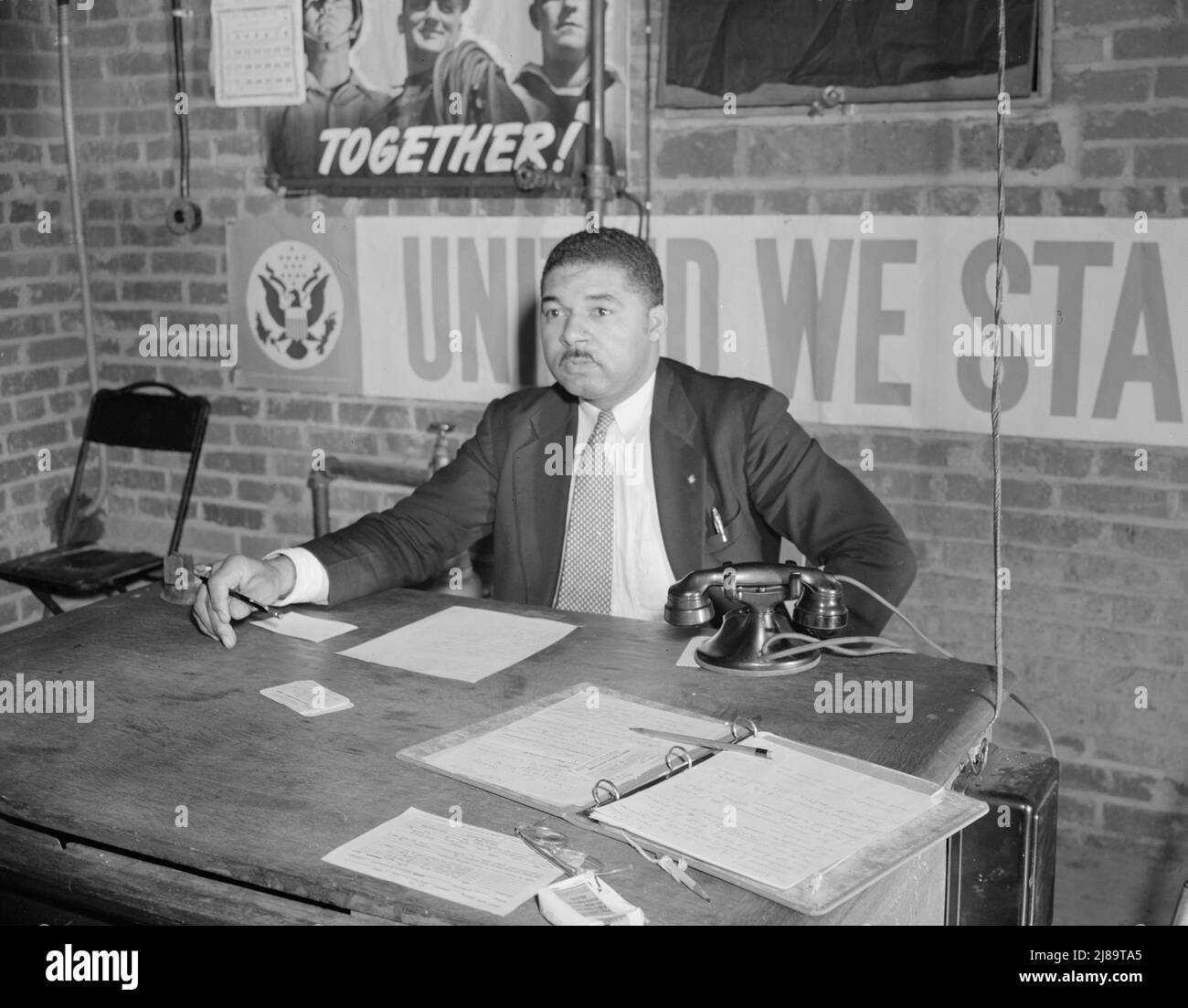 Washington, D.C. Air raid wardens' meeting in zone nine, Southwest area. Mr. Douglas Frederick, who is a firewatcher at the hotel where he is employed and a deputy warden in his neighborhood, presiding at a meeting of the wardens. Stock Photo