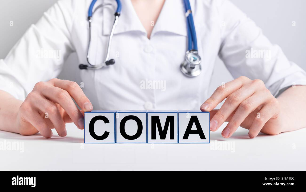 Coma word on medical cubes in doctor hands. High quality photo Stock Photo