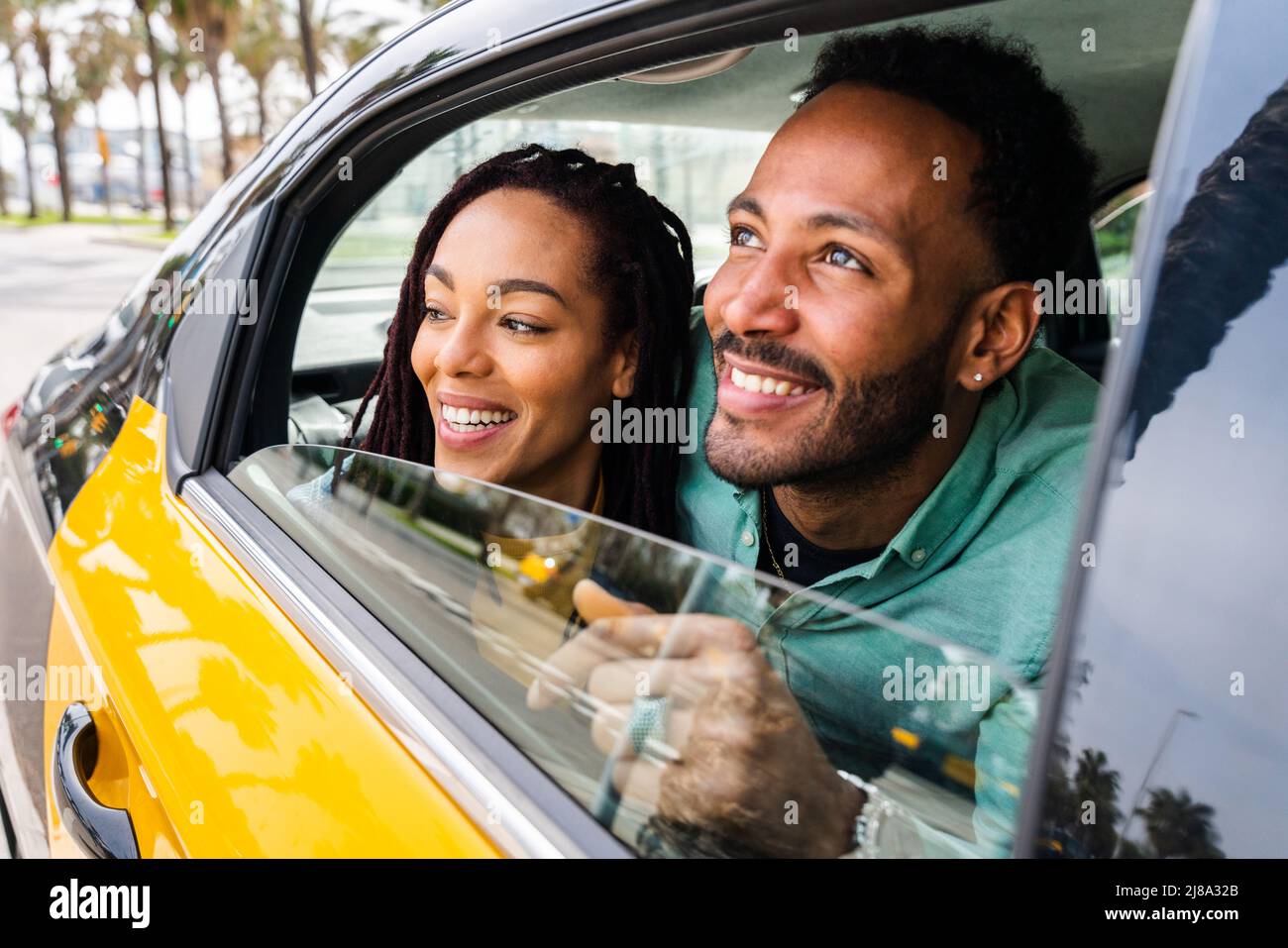 Beautiful happy hispanic latino couple of lovers dating outdoors - Tourists in Barcelona having fun during summer vacation and driving in a taxi cab Stock Photo