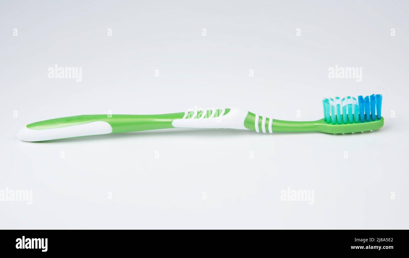 Green toothbrush for teeth on the white background Stock Photo