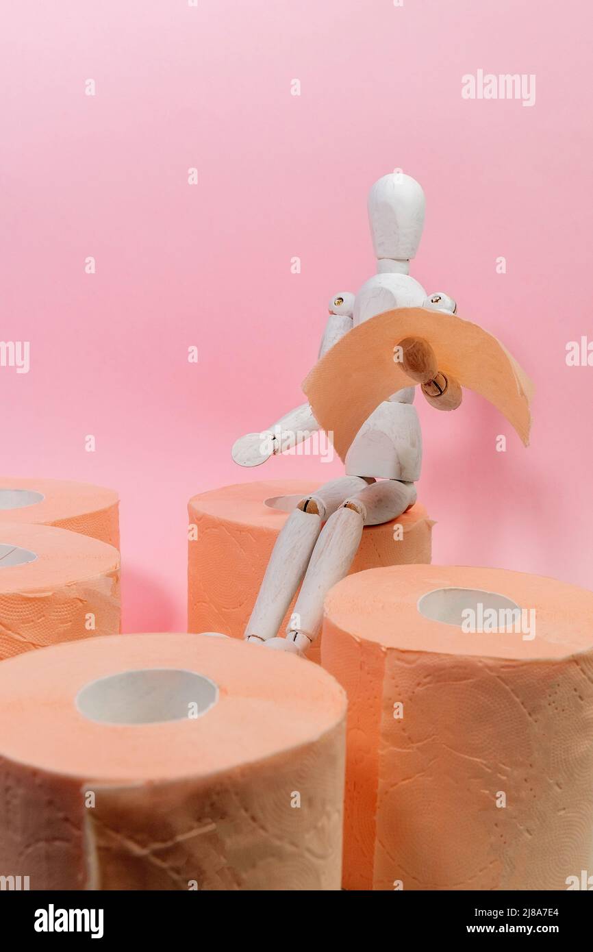 Toilet paper orange color with wooden maneken. Hygiene concept. Copy
