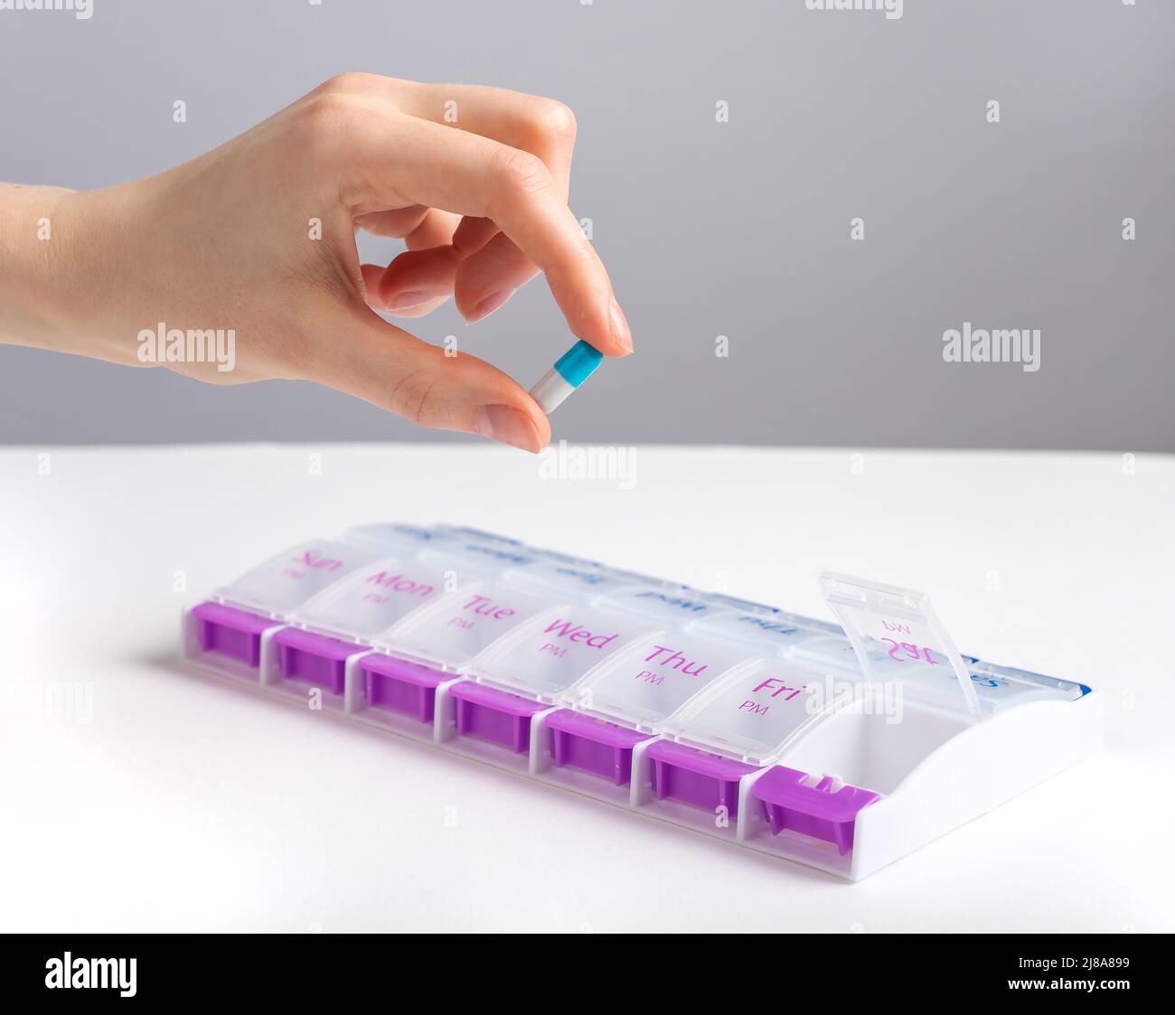 Hand taking capsule from pill case, bbo, organizer. High quality photo Stock Photo