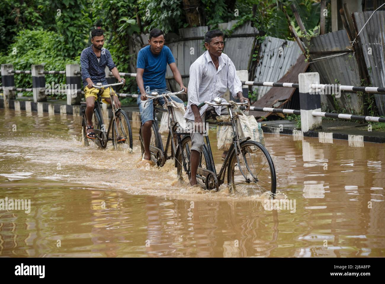 Commuters Make Their Way On A Waterlogged Street After A Heavy Rainfall In Guwahati India On 14