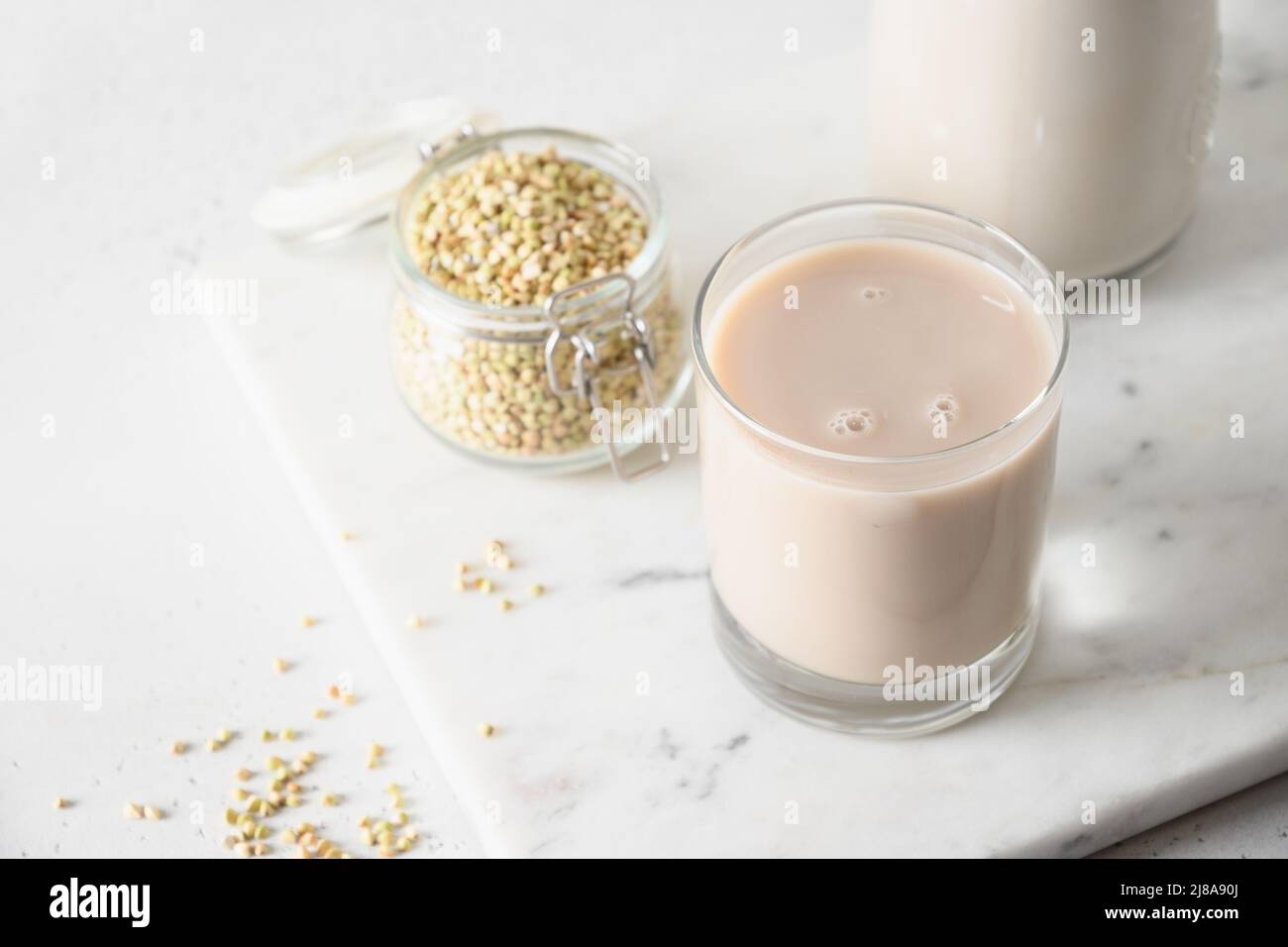 Vegan cereal green buckwheat milk in glass on white background. Close