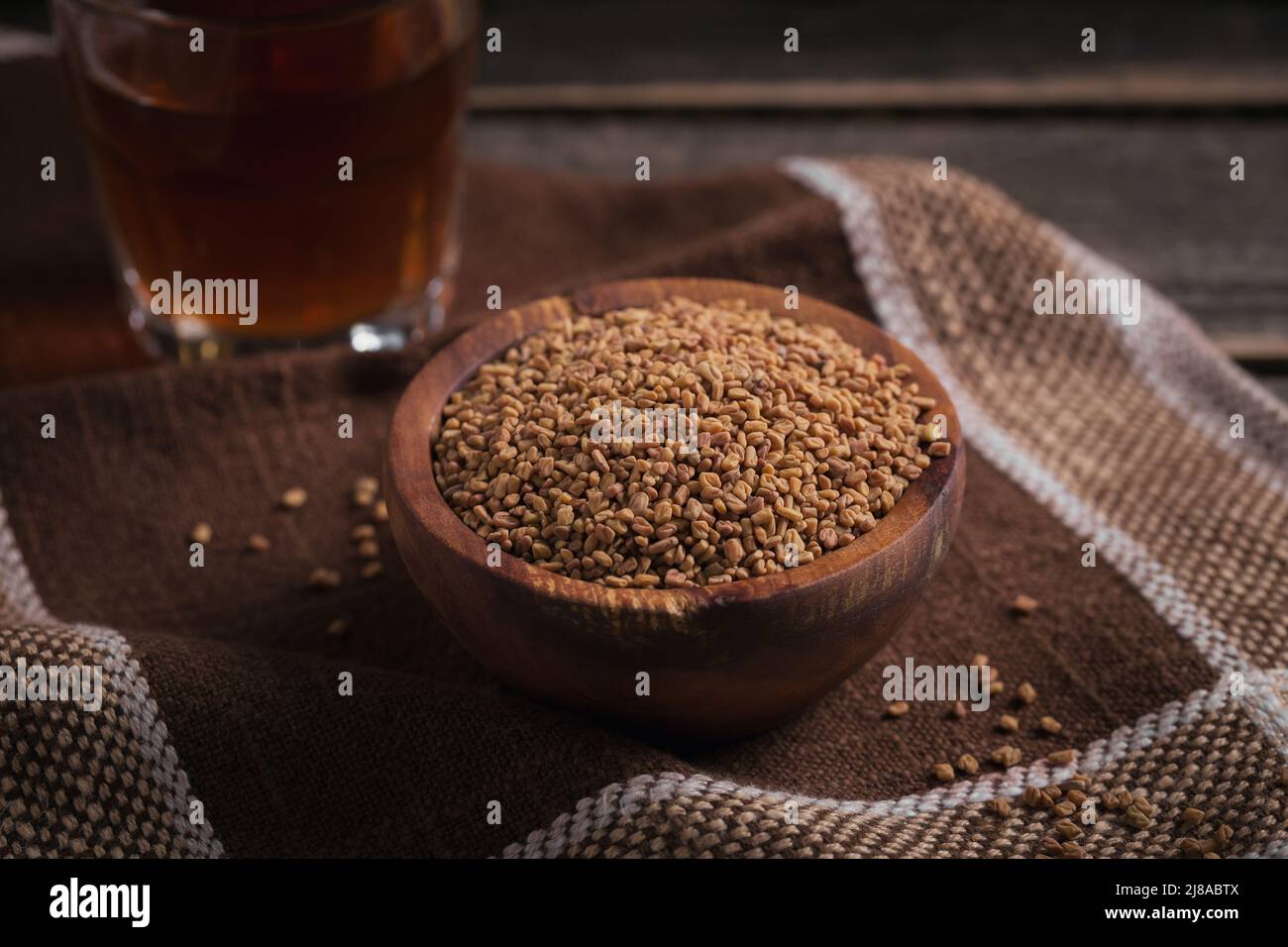 Bowl of fenugreek seeds and Egyptian fenugreek yellow tea or Methi Dana drink Stock Photo
