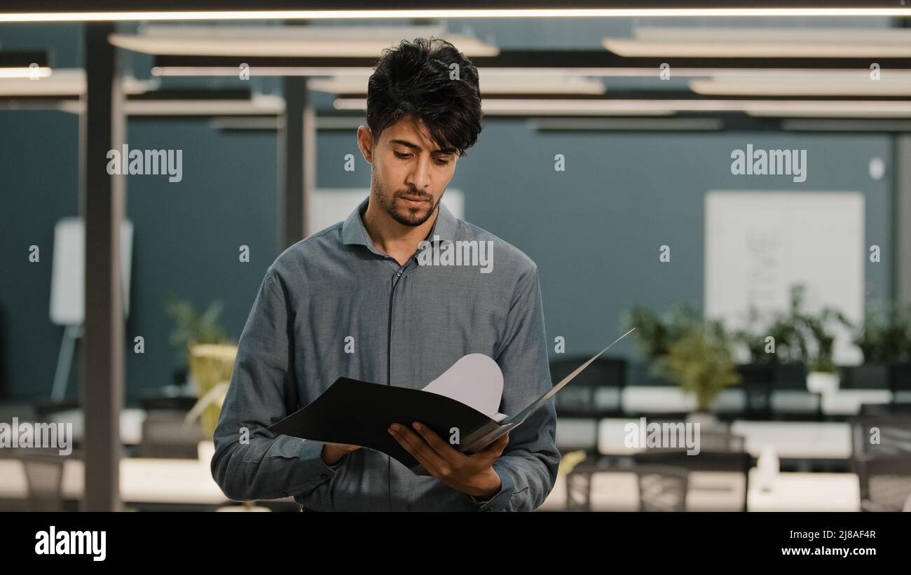 Shocked Arabian multiracial businessman feel stress checking business report paperwork man worries of financial problem company looking frustrated Stock Photo