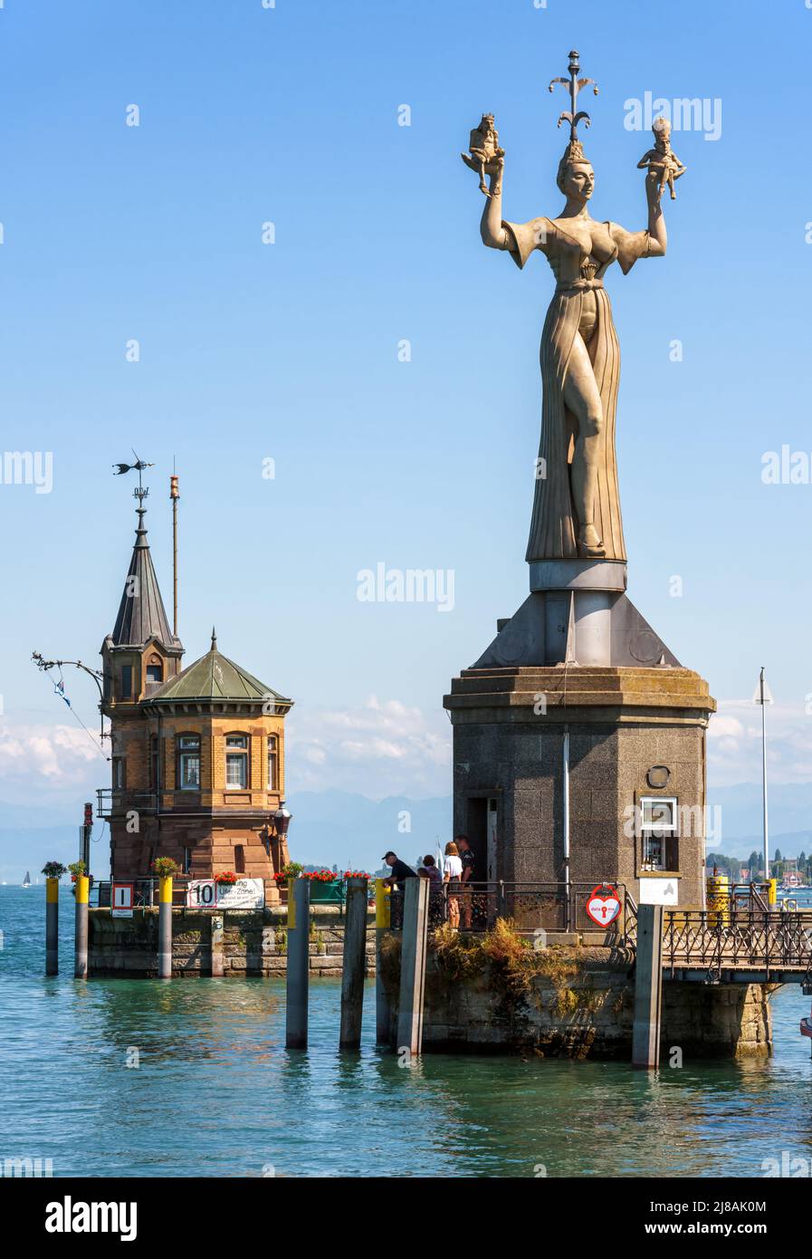 Constance, Germany - July 30, 2019: Old lighthouse and statue of Imperia in harbor of Konstanz. Sculpture is tourist attraction of city. Scenery of Co Stock Photo