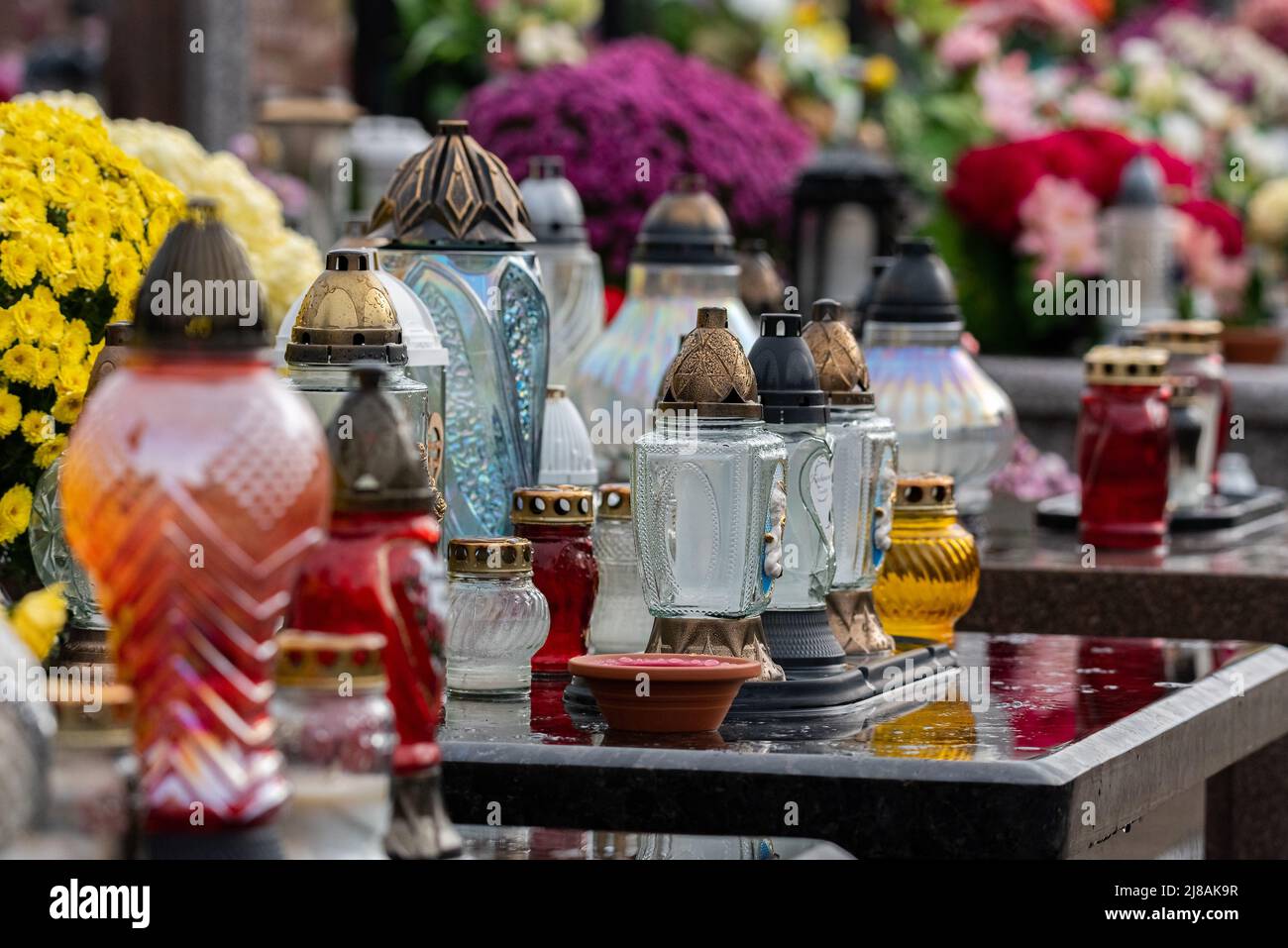 All Saints' Day and burning candles next to flowers on the graves