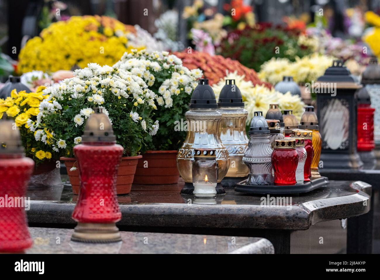 All Saints' Day and burning candles next to flowers on the graves