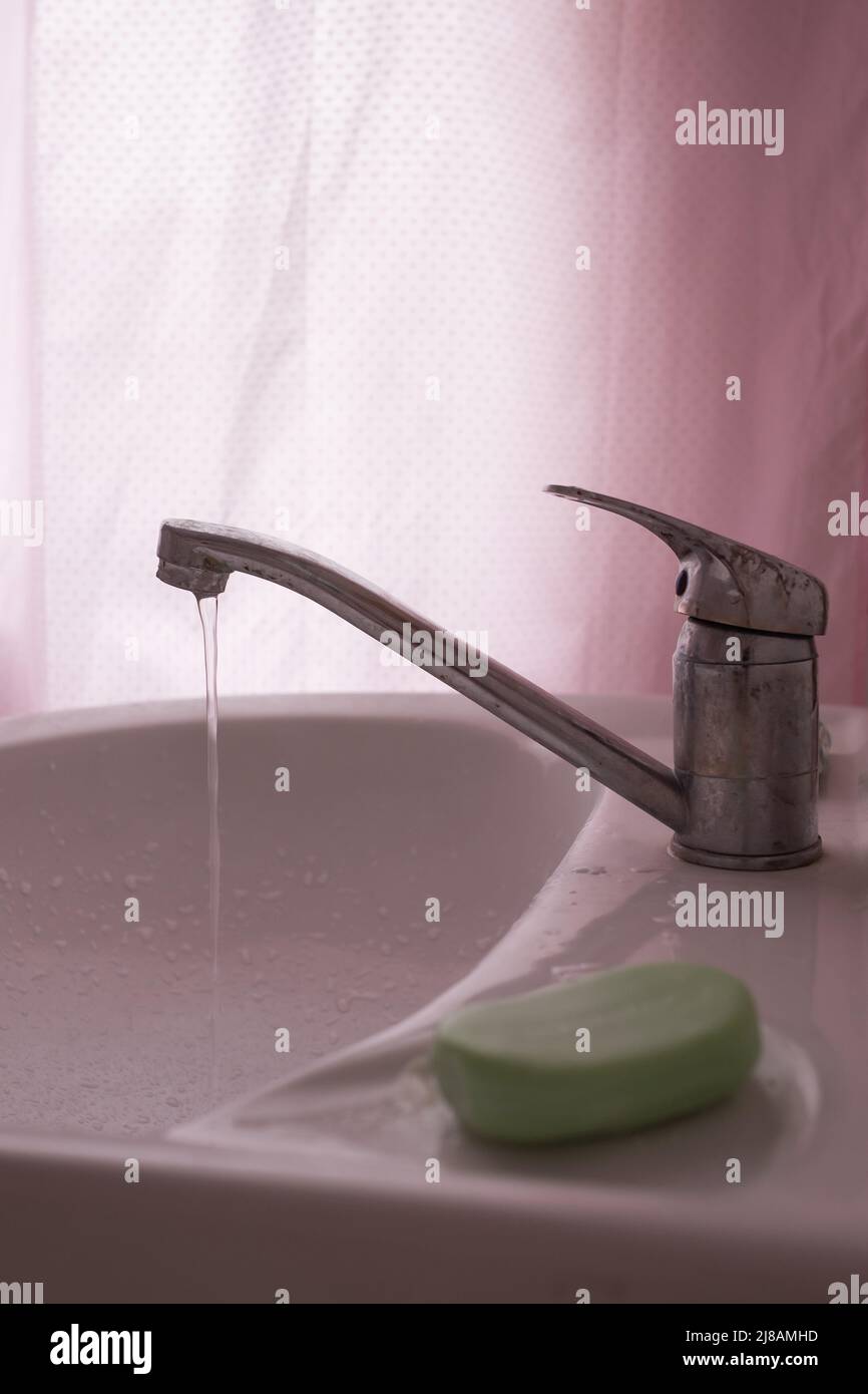 faucet with flowing water in wash sink. Somebody to turn off