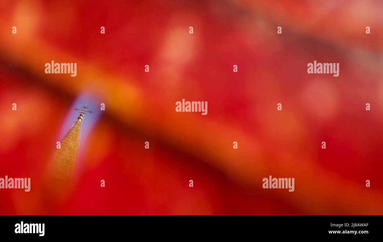 Bucharest, Romania - October 13, 2018: The Maramures church from Dragomiresti can be seen through a hole in a red leaf, at the Dimitrie Gusti National Stock Photo