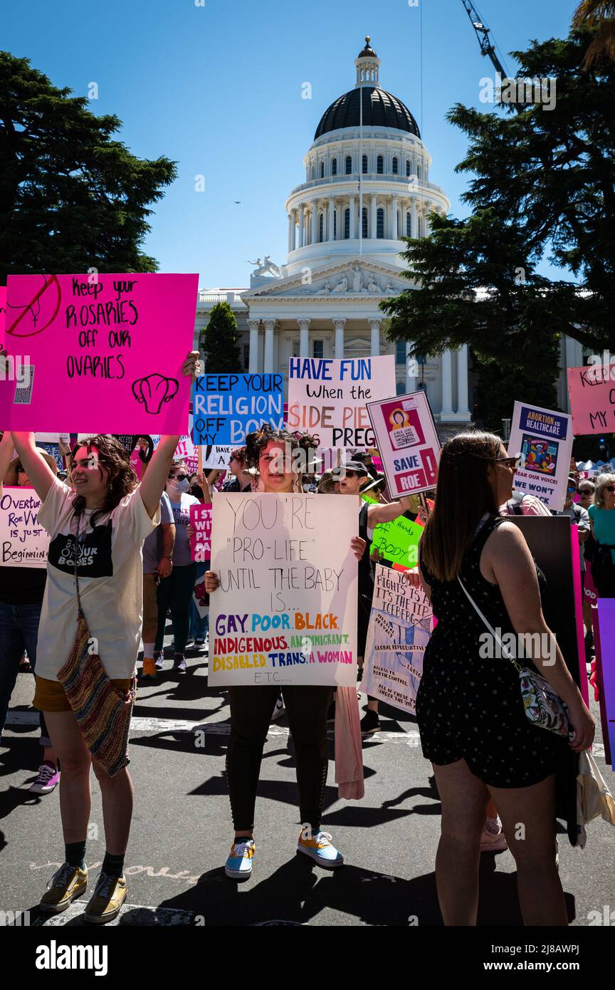 A woman holds a protest sign around in front of the state capitol during thRoe Bans off our Bodies March and  Rally organized by Planned Parenthood. Stock Photo