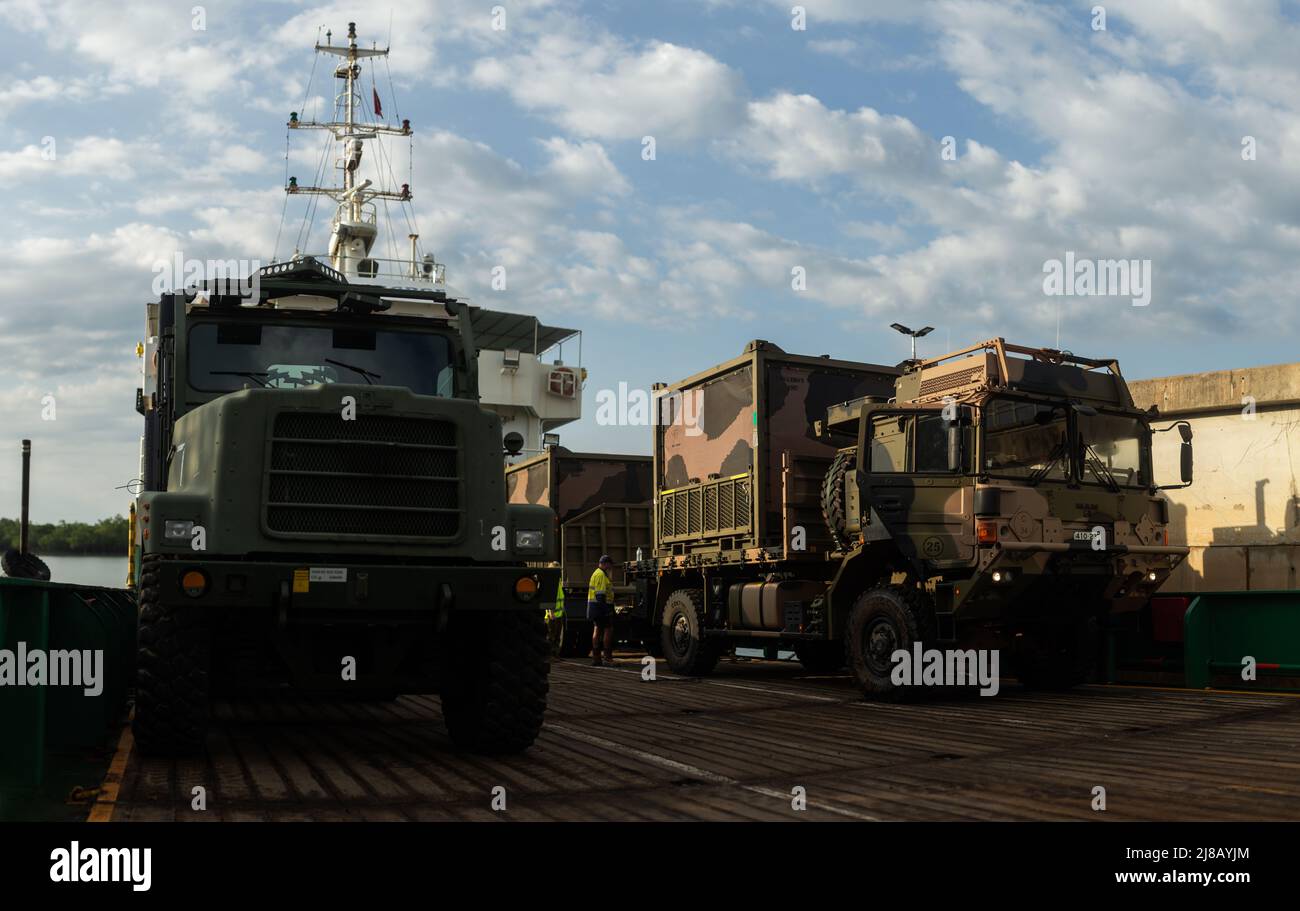 An Australian Army MAN 40M Truck loaded with water purification systems (right), belonging to 1st Combat Engineer Regiment, 1st Field Squadron, is staged on a barge next to a U.S. Marine Corps Medium Tactical Vehicle Replacement, belonging to Logistics Command Element, Marine Rotational Force-Darwin (MRF-D) 22, during a combined logistics movement of equipment for exercise Crocodile Response 22 at Darwin, NT, Australia, May 12, 2022. MRF-D 22 and Australian Army equipment was loaded onto civilian barges for transportation, demonstrating the flexibility to conduct humanitarian assistance and di Stock Photo