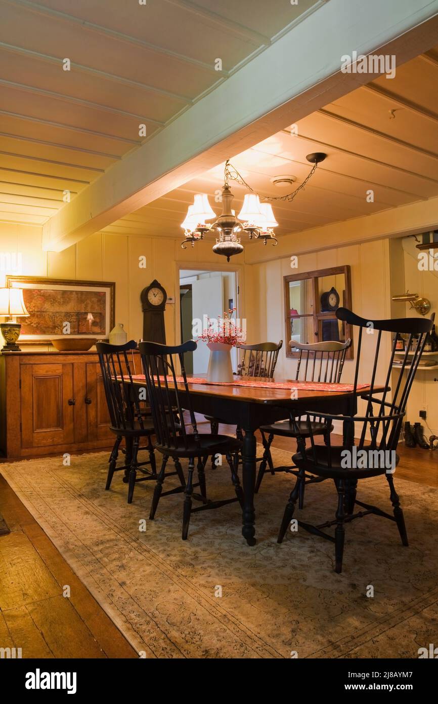 Antique wooden dining table and high back Windsor chairs in dining room