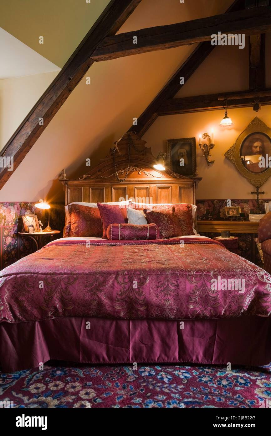 Queen size bed with purple velvet bedspread in main bedroom on upstairs