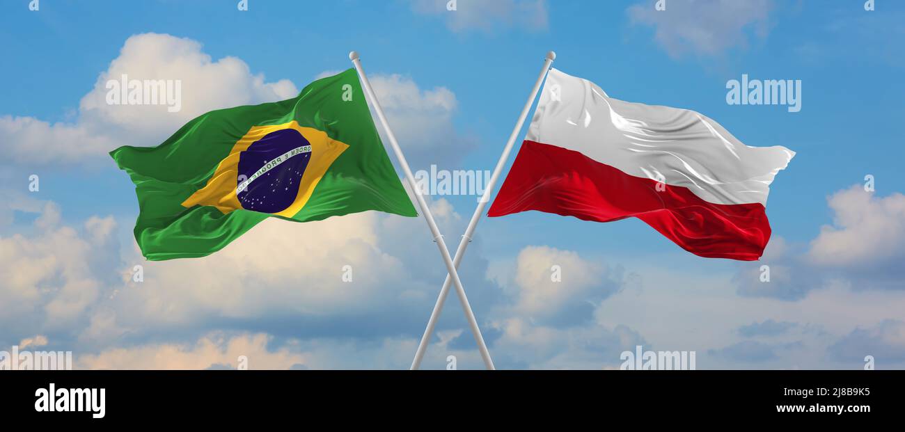 two crossed flags Brazil and Poland waving in wind at cloudy sky ...