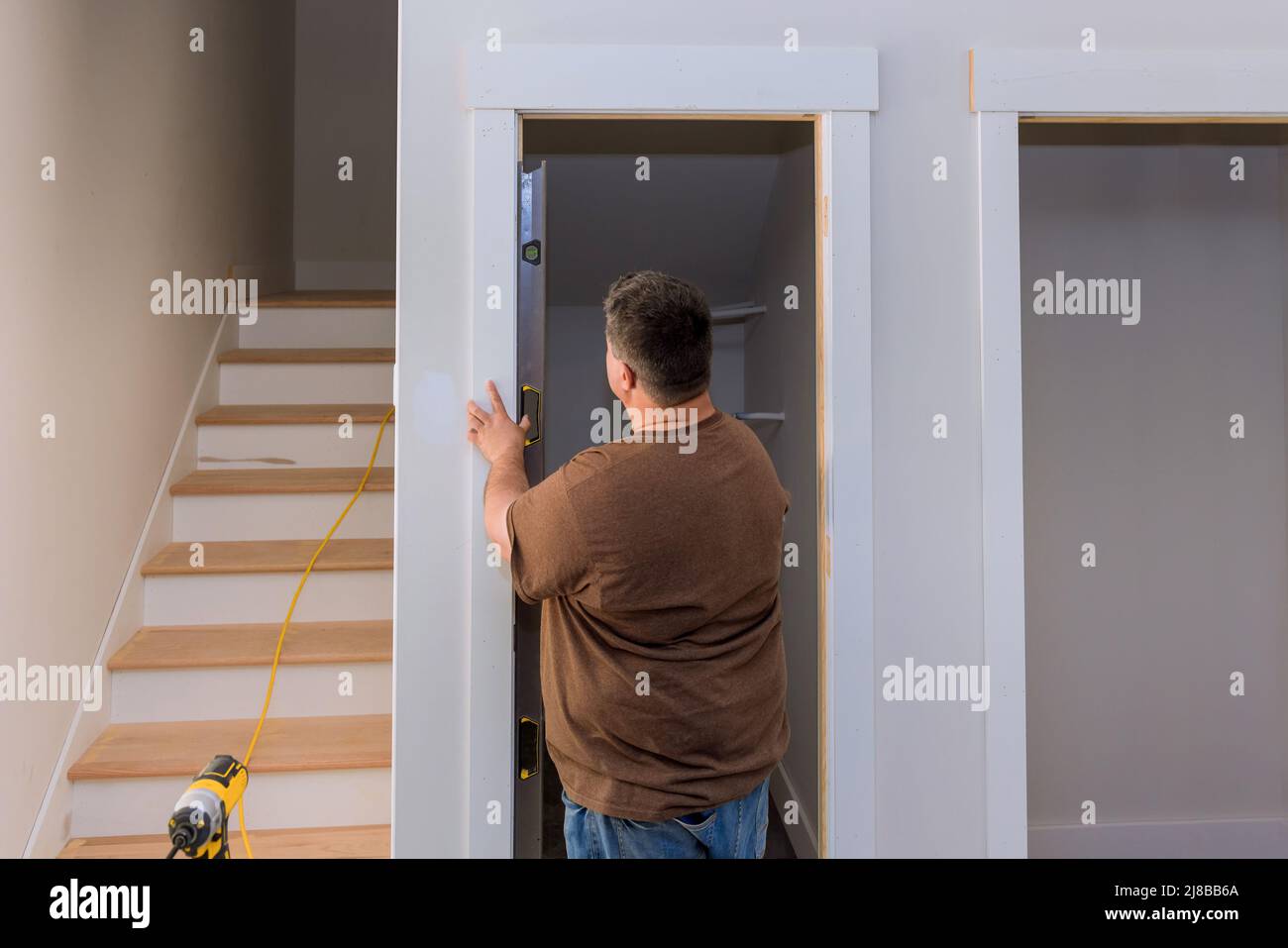 Carpenter at checks level correctness installation door Stock Photo Alamy