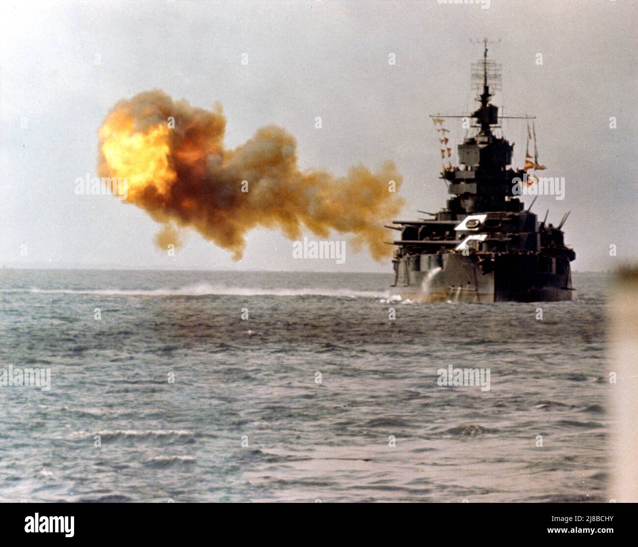 Battleship USS Idaho firing on Okinawa during World War II. Stock Photo
