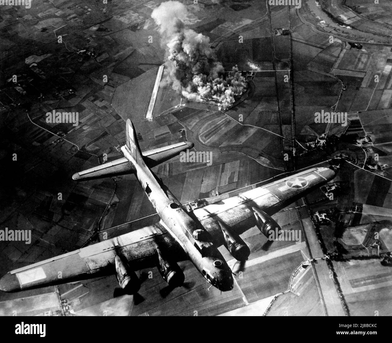 A Boeing B-17F (“Virgin’s Delight,” of the 410th Bomb Squadron, 94th Bombardment Group (Heavy), 8th Air Force,) flying over the burning Focke Wulf factory at Marenburg in Germany. This raid was a success in that the precision bombing meant that the factory was heavily damaged. However the distance that the planes had to fly back to the UK meant that the Luftwaffe had plenty of time to regroup at inflict heavy losses on the bombers. Stock Photo