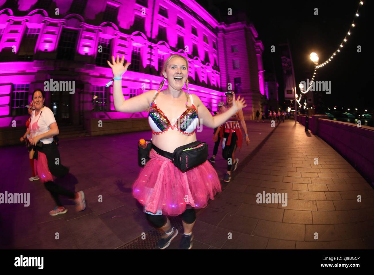 London, UK. 14th May 2022. London, UK. Participants at the Walk the Walk Moonwalk walking through London wearing decorated bras fundraising for breast cancer charities doing a marathon overnight. This year the theme is 'Your Heroes' and there were numerous rainbow themed costumes and bras in support of NHS heroes, also many superhero costumes and even blue and yellow Ukranian flag themed costumes in support of Ukrainian heroes. Credit: Paul Brown/Alamy Live News Stock Photo