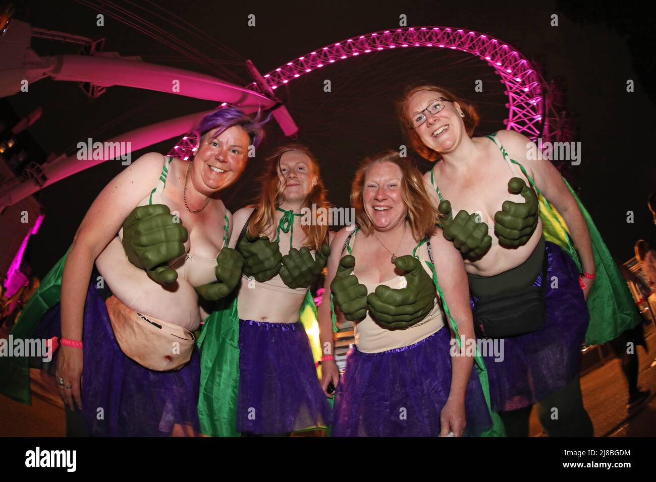 London, UK. 14th May 2022. London, UK. Participants dressed as their hero the Incredible Hulk passing the London Eye at the Walk the Walk Moonwalk walking through London wearing decorated bras fundraising for breast cancer charities doing a marathon overnight. This year the theme is 'Your Heroes' and there were numerous rainbow themed costumes and bras in support of NHS heroes, also many superhero costumes and even blue and yellow Ukranian flag themed costumes in support of Ukrainian heroes. Credit: Paul Brown/Alamy Live News Stock Photo