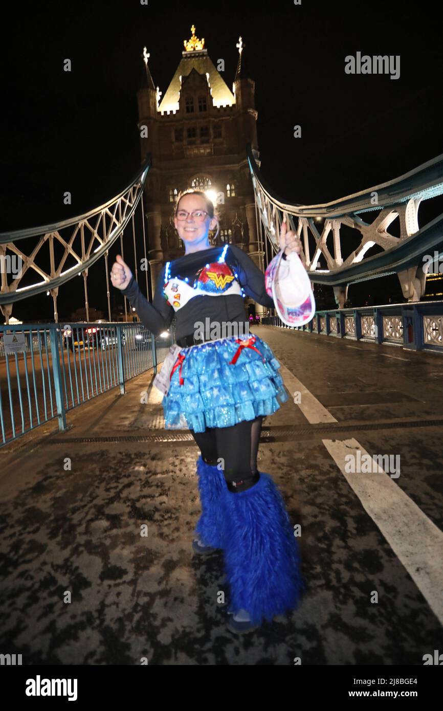 London, UK. 14th May 2022. London, UK. Participant on Tower Bridge at the Walk the Walk Moonwalk walking through London wearing decorated bras fundraising for breast cancer charities doing a marathon overnight. This year the theme is 'Your Heroes' and there were numerous rainbow themed costumes and bras in support of NHS heroes, also many superhero costumes and even blue and yellow Ukranian flag themed costumes in support of Ukrainian heroes. Credit: Paul Brown/Alamy Live News Stock Photo
