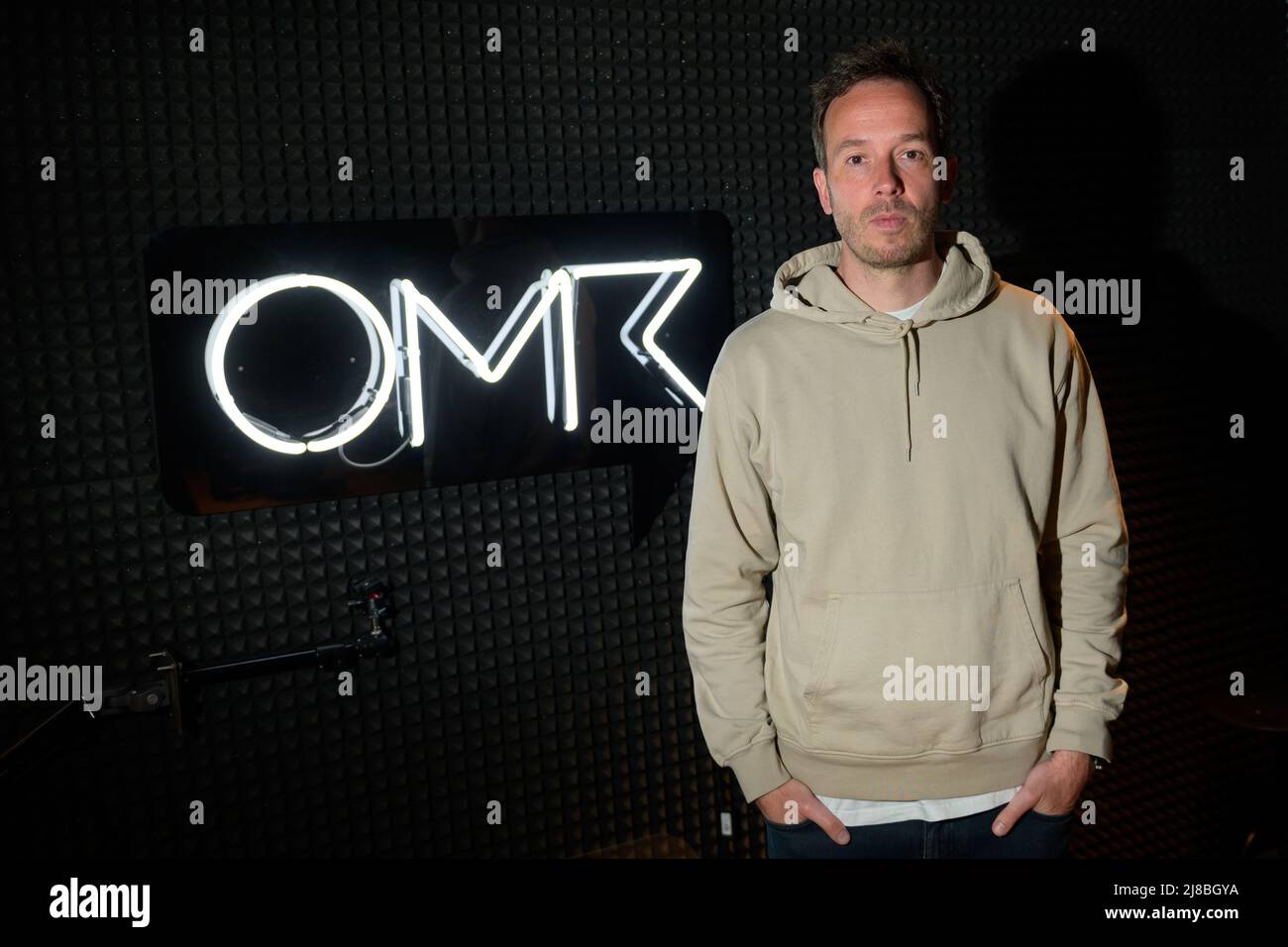 26 April 2022, Hamburg: OMR boss Philipp Westermeyer stands next to an OMR logo in his podcast studio. (to dpa: OMR in Hamburg - Digital trade fair with star-studded line-up and good music) Photo: Jonas Walzberg/dpa Stock Photo