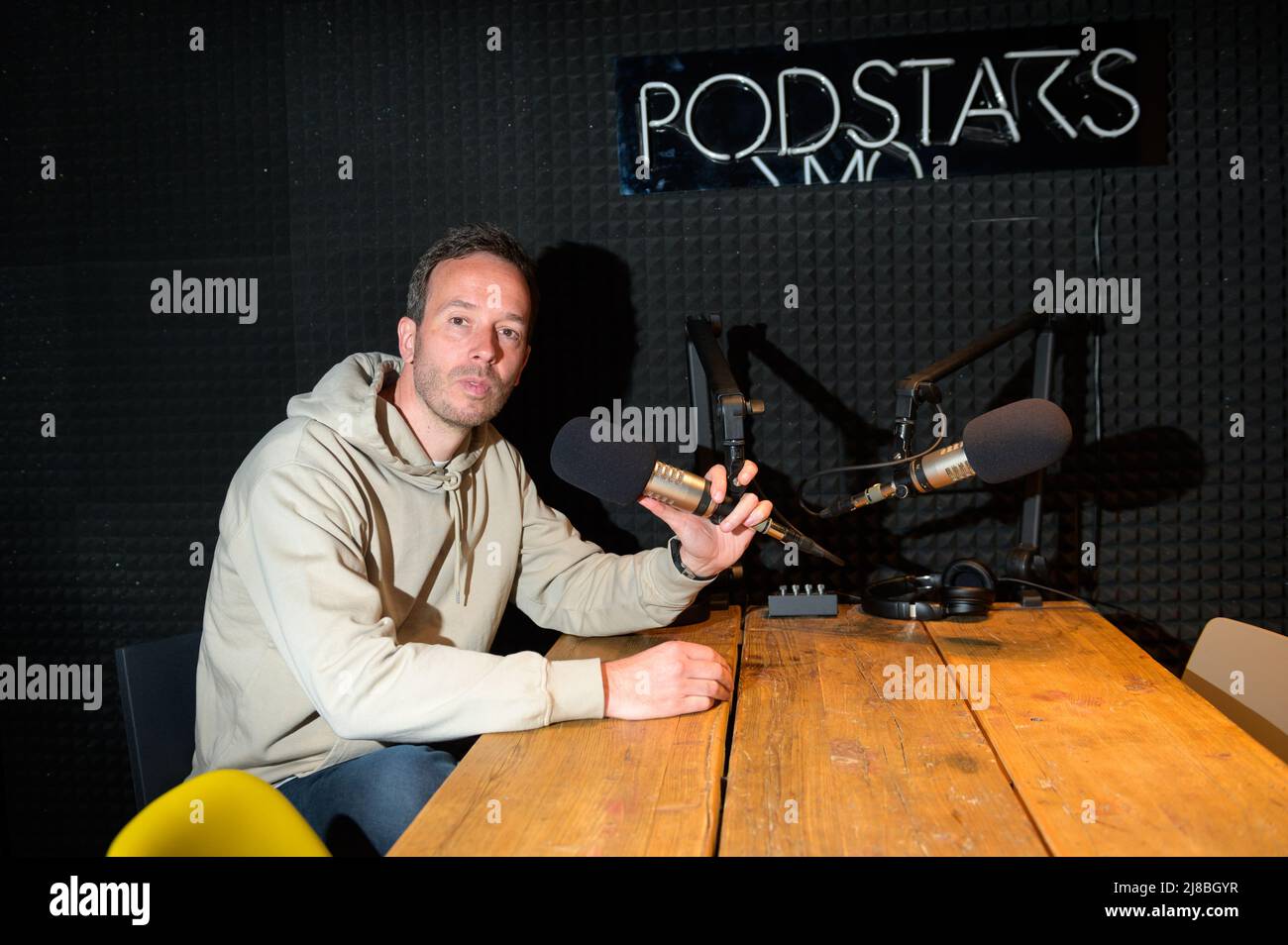 26 April 2022, Hamburg: OMR boss Philipp Westermeyer sits in his podcast studio next to the Podstars logo. (to dpa: OMR in Hamburg - Digital trade fair with star-studded line-up and good music) Photo: Jonas Walzberg/dpa Stock Photo