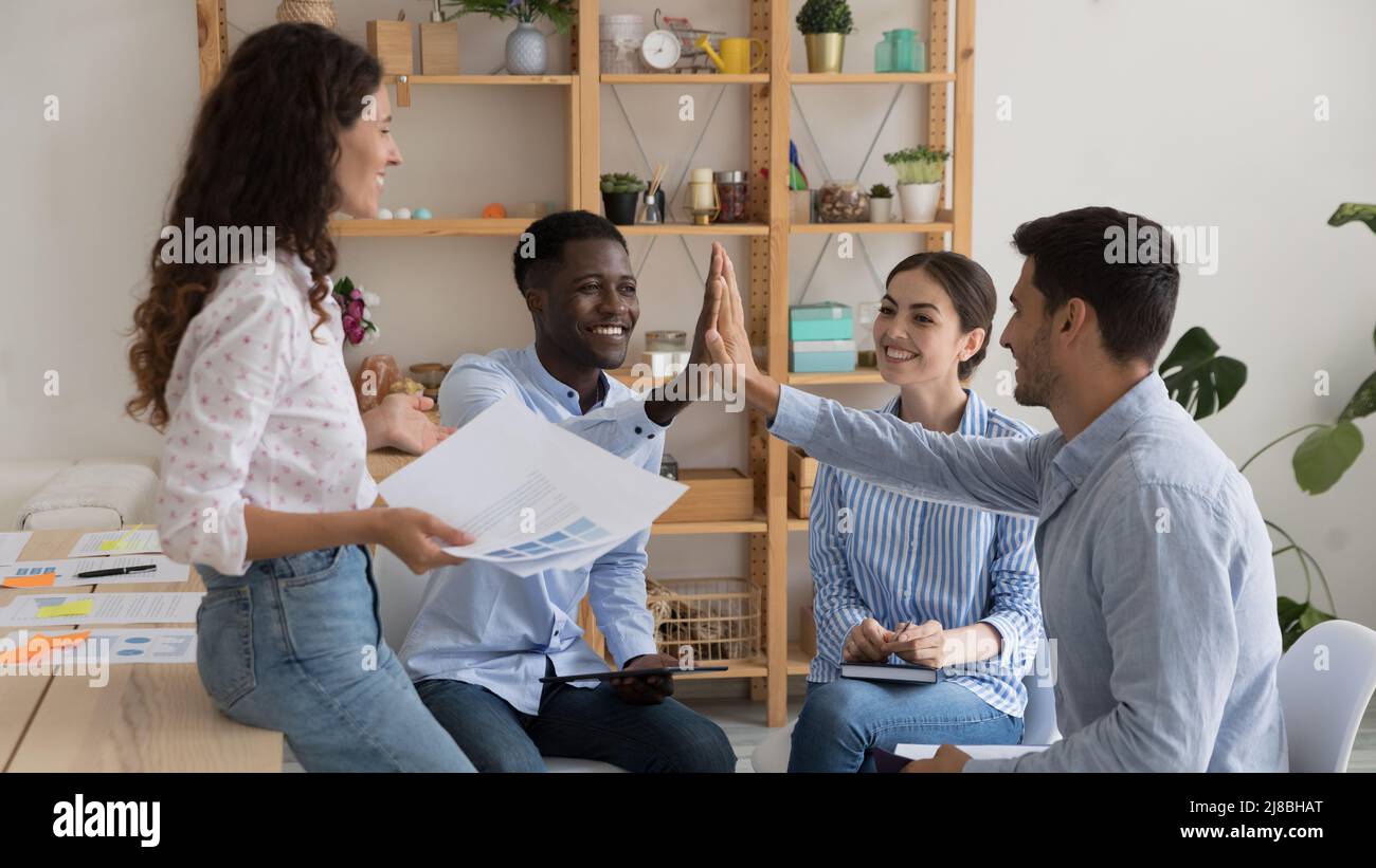 Happy diverse business team friends giving high five Stock Photo - Alamy