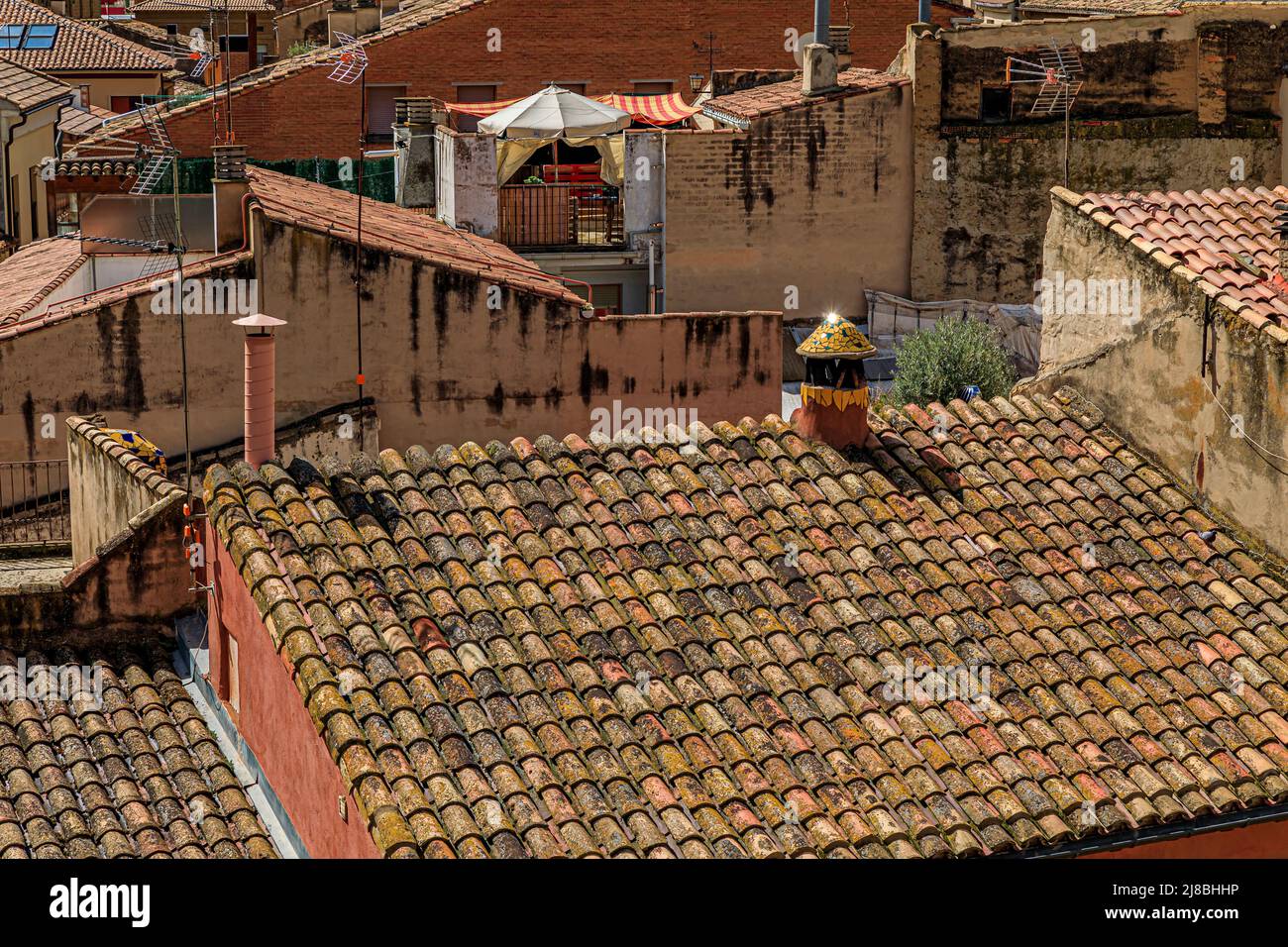 Aerial view of terracotta tiles of the roofs of medieval stone houses in Olite, Spain famous for a magnificent Royal Palace castle Stock Photo
