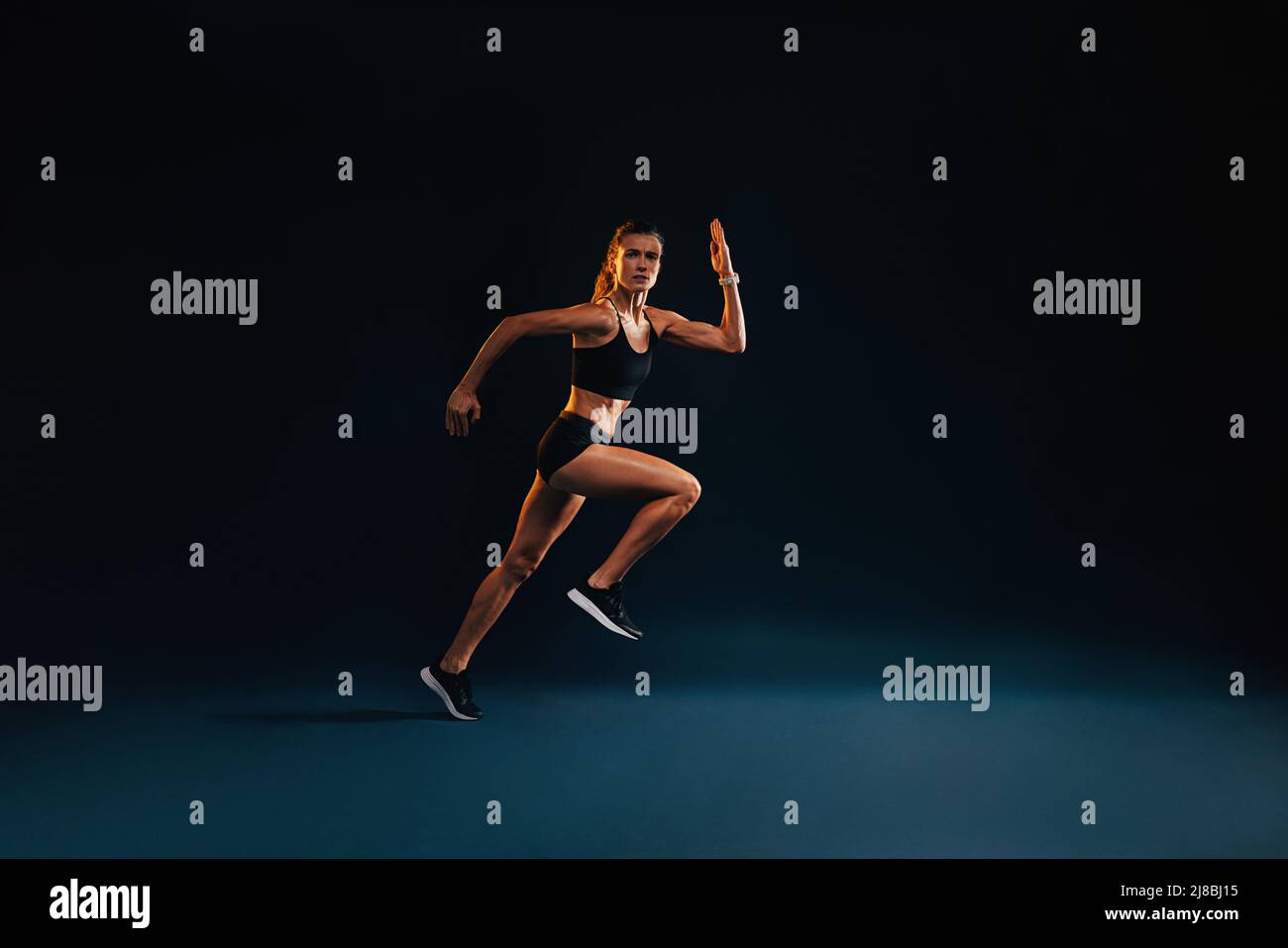 Athlete in starting position for running against black background stock  photo