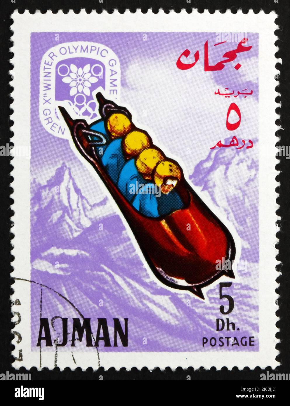 AJMAN - CIRCA 1967: a stamp printed in the Ajman shows Four-man Bobsled, Winter Olympics 68, Grenoble, circa 1967 Stock Photo