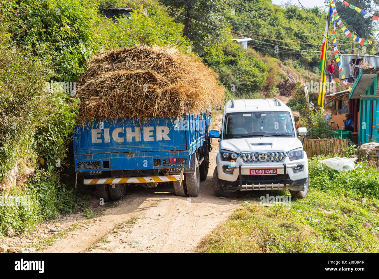 Nepal - October 29, 2021: Two vehicles meet on a narrow mountain road in the Himalaya mountains of Nepal. The cars meander past each other to avoid cr Stock Photo